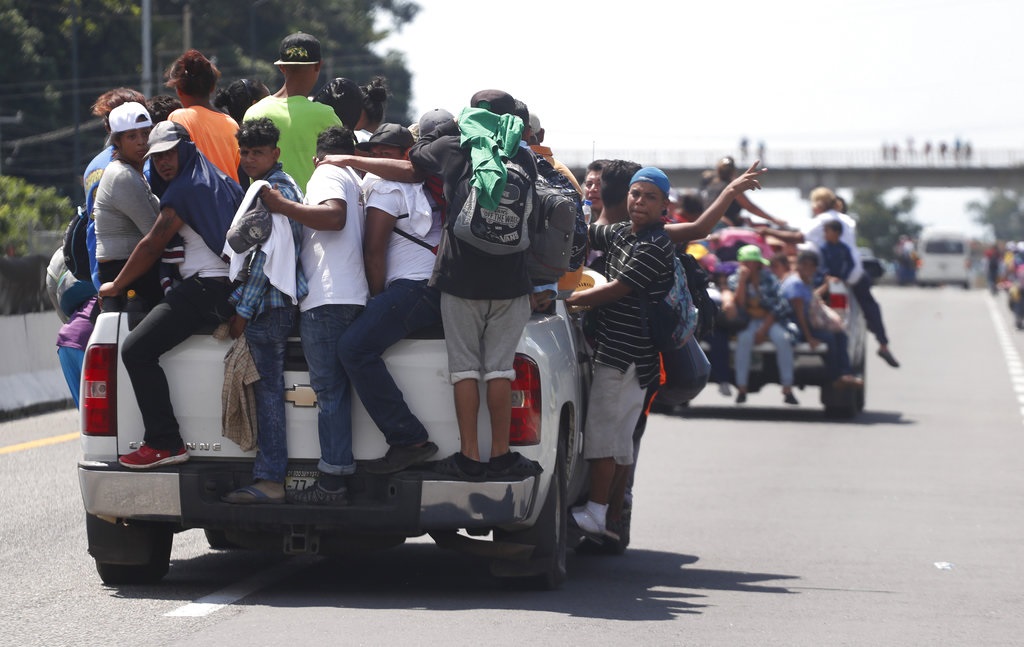 Los migrantes centroamericanos se dirigen a los Estados Unidos en una gran caravana aferrada a los camiones de los conductores que les ofrecieron viajes gratis, cuando llegan a Tapachula, México.