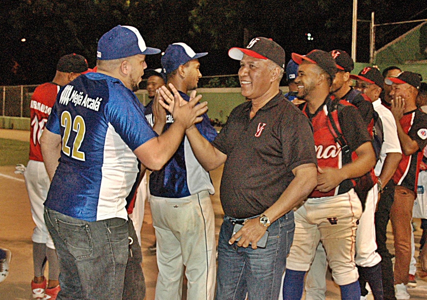 El general (r) Manuel Castro Castillo (derecha), felicita al conjunto de Los Mellos que vencieron a Villa Juana en una final 3-2 para coronarse en el torneo de sóftbol junior de ligas del Distrito Nacional.