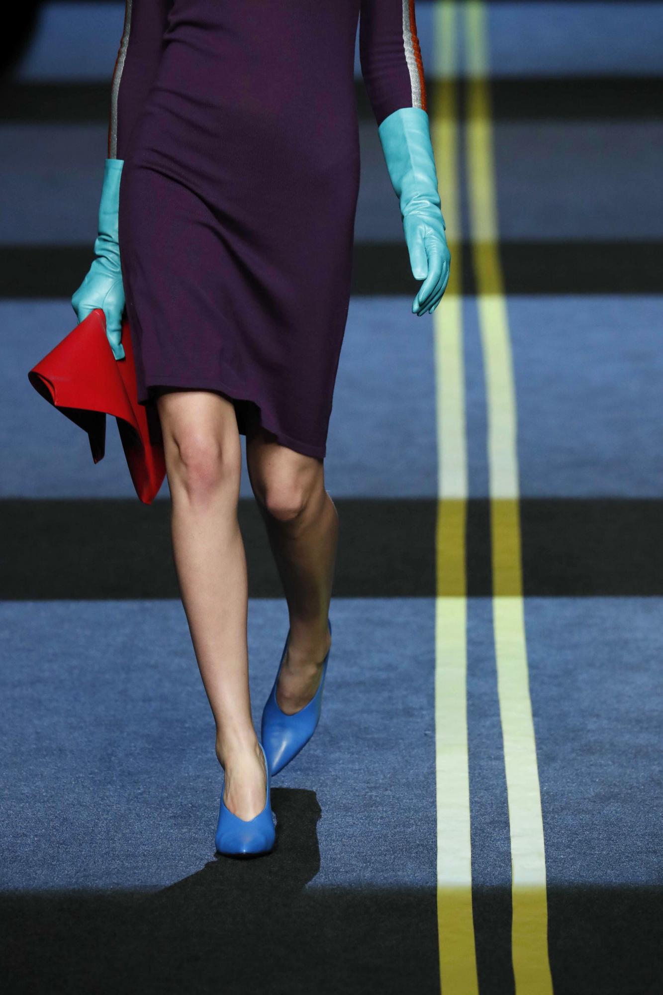 Vestido morado combinado con complementos en tonos azules y cartera de mano rojo, una creación de Moisés Nieto. 