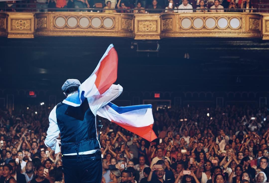 Juan Luis, con la bandera dominicana, en el United Palace