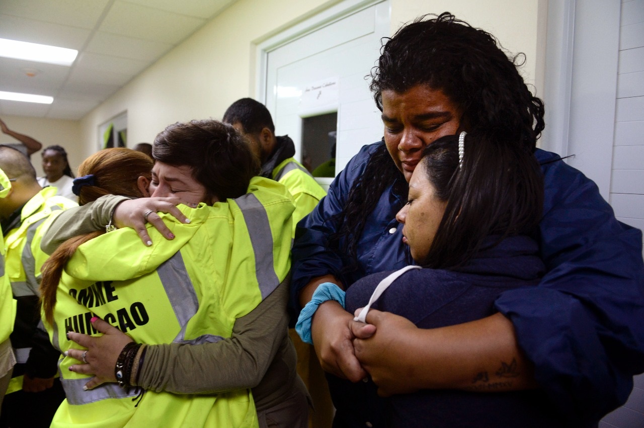 Mujeres rescatistas se abrazan angustiadas ante no poder salir a hacer su trabajo como miembro de la Oficina de Manejo Municipal de Emergencias (OMME), en Puerto Rico, en momentos que el ojo del huracán golpea la isla.