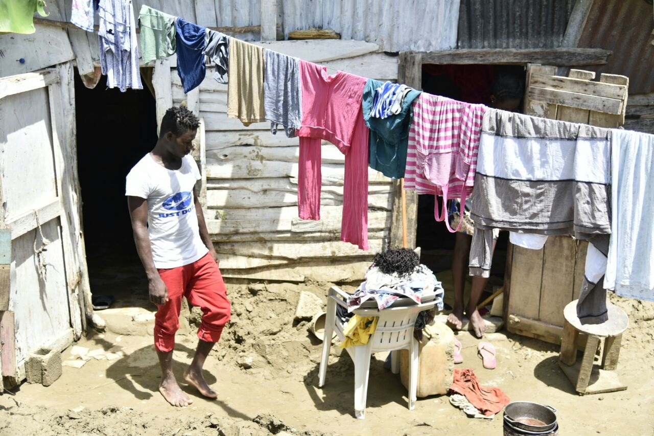 Estos dos hombres en medio del lodazal en el sector El Tamarindo, en La Vega, caminan sin protegerse los pies, a pesar del riesgo que conlleva.