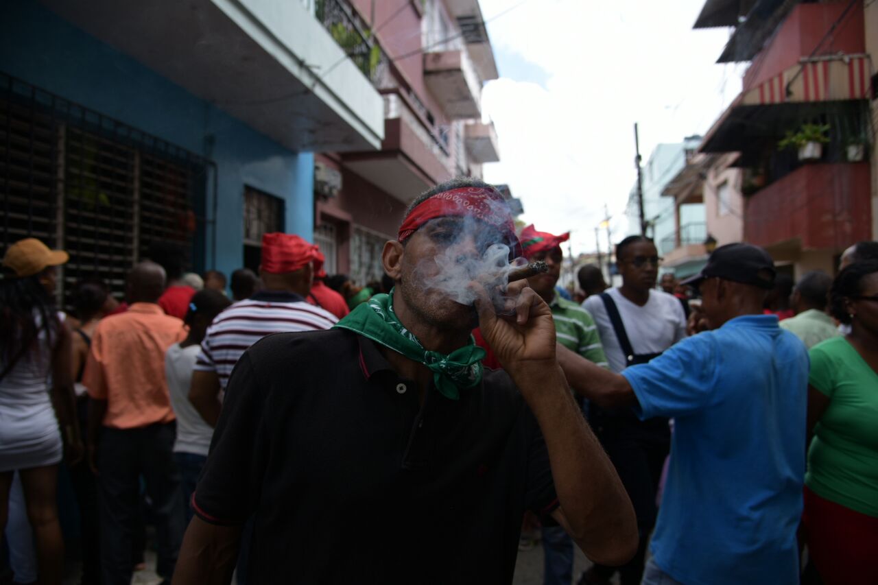 Devotos de San Miguel Arcángel usan atuendos rojos y algunos fuman tabaco. 