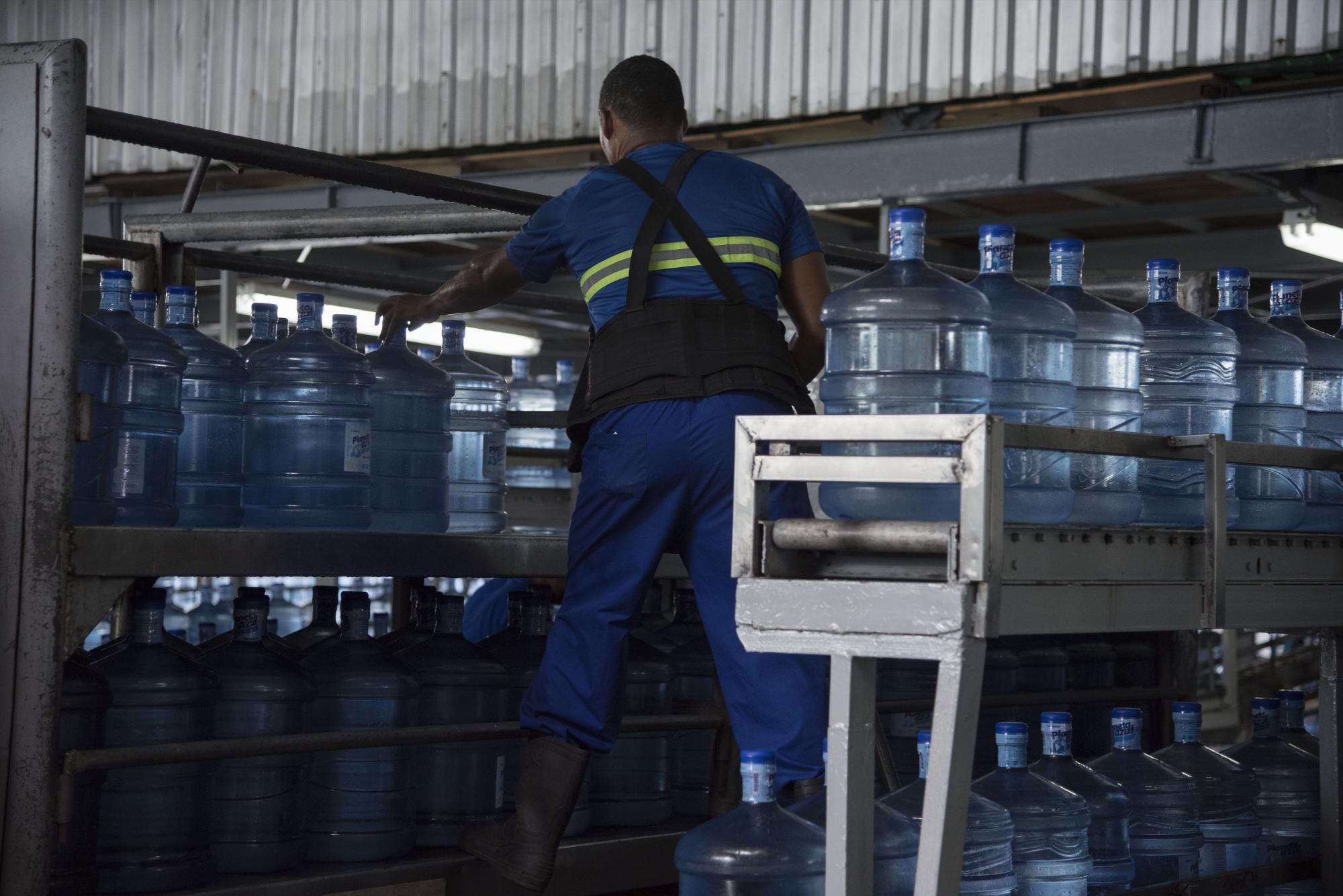 Cuando los botellones están llenos, tapados y etiquetados, el personal lo prepara para subirlo al camión de distribución.