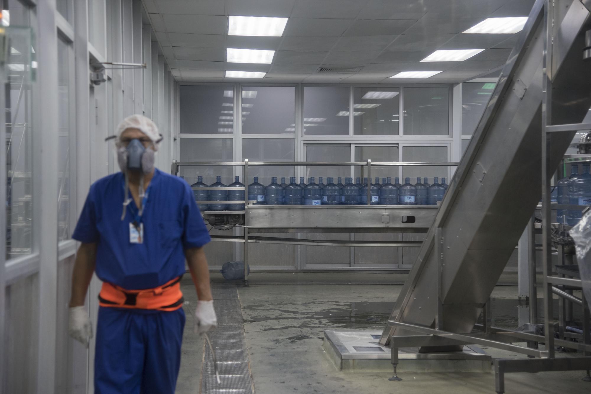 Un personal vigila que los galones estén aptos para pasar al proceso de llenado.