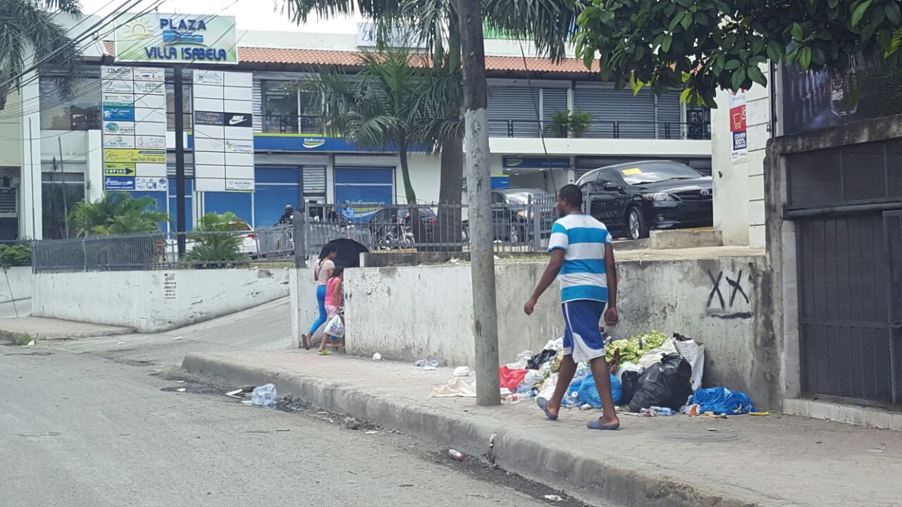 Un joven camina cerca de un cúmulo de basura La Isabela, Santo Domingo Norte.