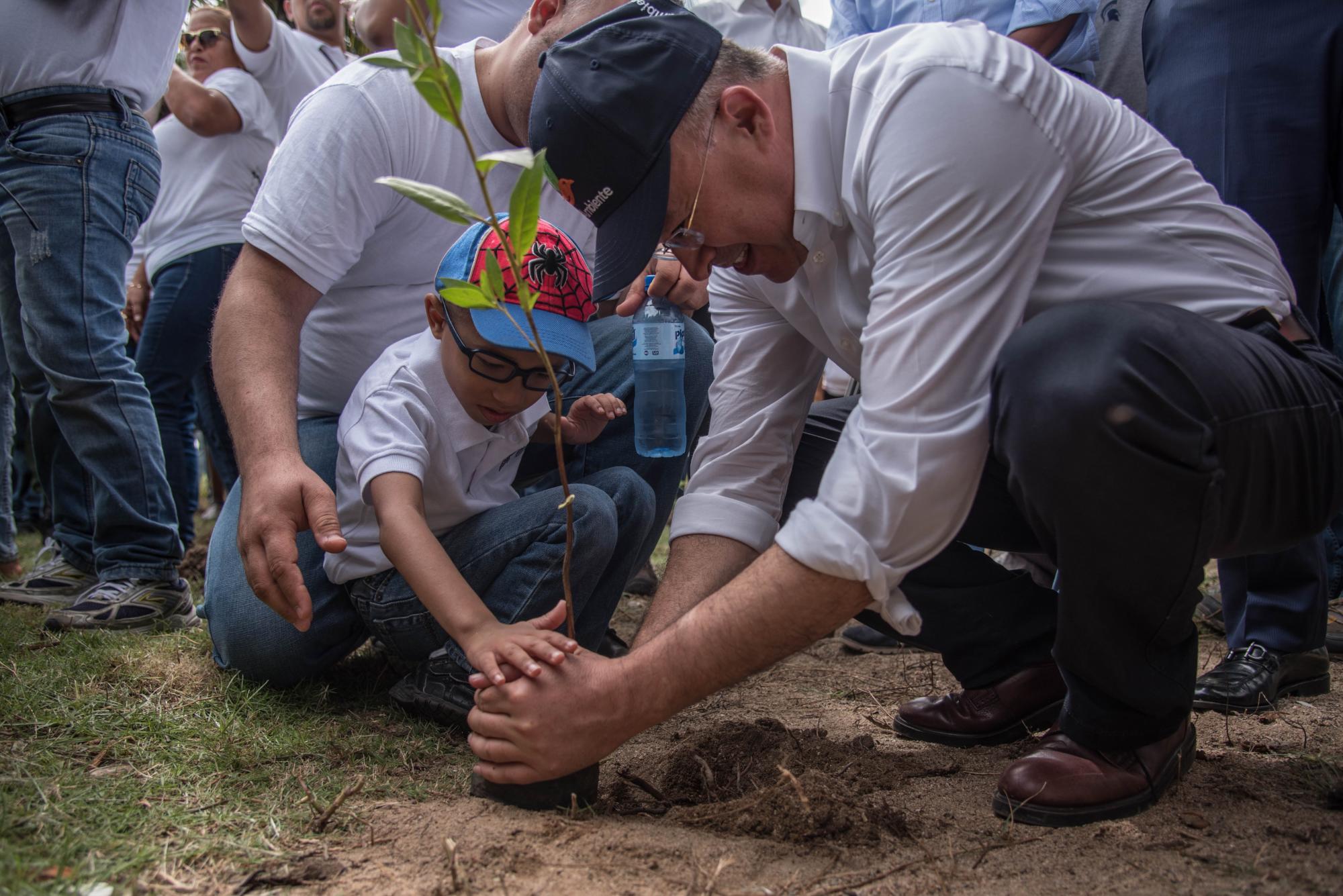 El Ministro Francisco Domínguez Brito siembra un árbol junto a un niño del  CAID.