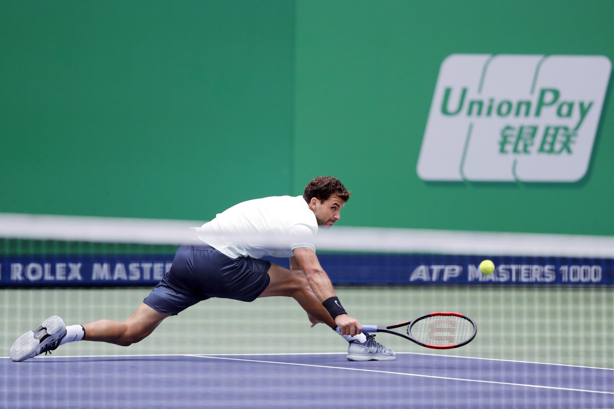Grigor Dimitrov alcanza el balón cuando juega contra Rafael Nadal durante el partido de cuartos de final masculino en el torneo de tenis Masters de Shanghai el 13 de octubre de 2017.