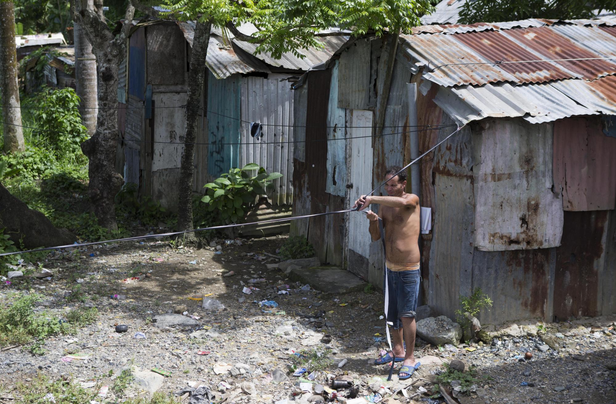 Fotografía fechada el 11 de octubre de 2017 que muestra a Emmanuel mientras trabaja en su casa en Villa Heloisa, en el sector de Las Cañitas, a orillas del río Ozama, en Santo Domingo.