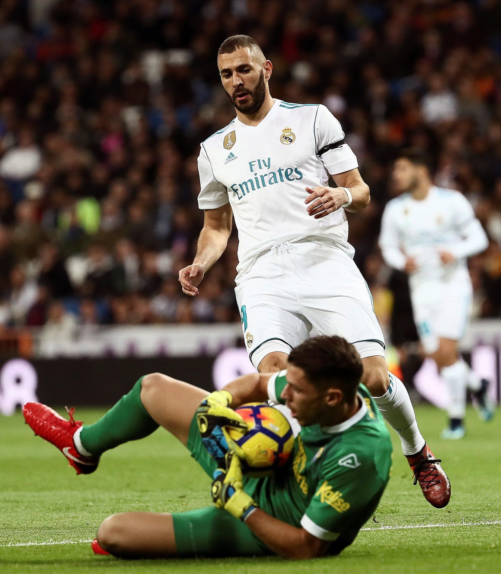 El jugador francés del Real Madrid Karim Benzema (c), pelea un balón con el jugador de la Unión Deportiva Las Palmas Raúl Lizoain , durante el partido de LaLiga entre Real Madrid y la Unión Deportiva Las Palmas en el estadio Santiago Bernabeu de Madrid. 