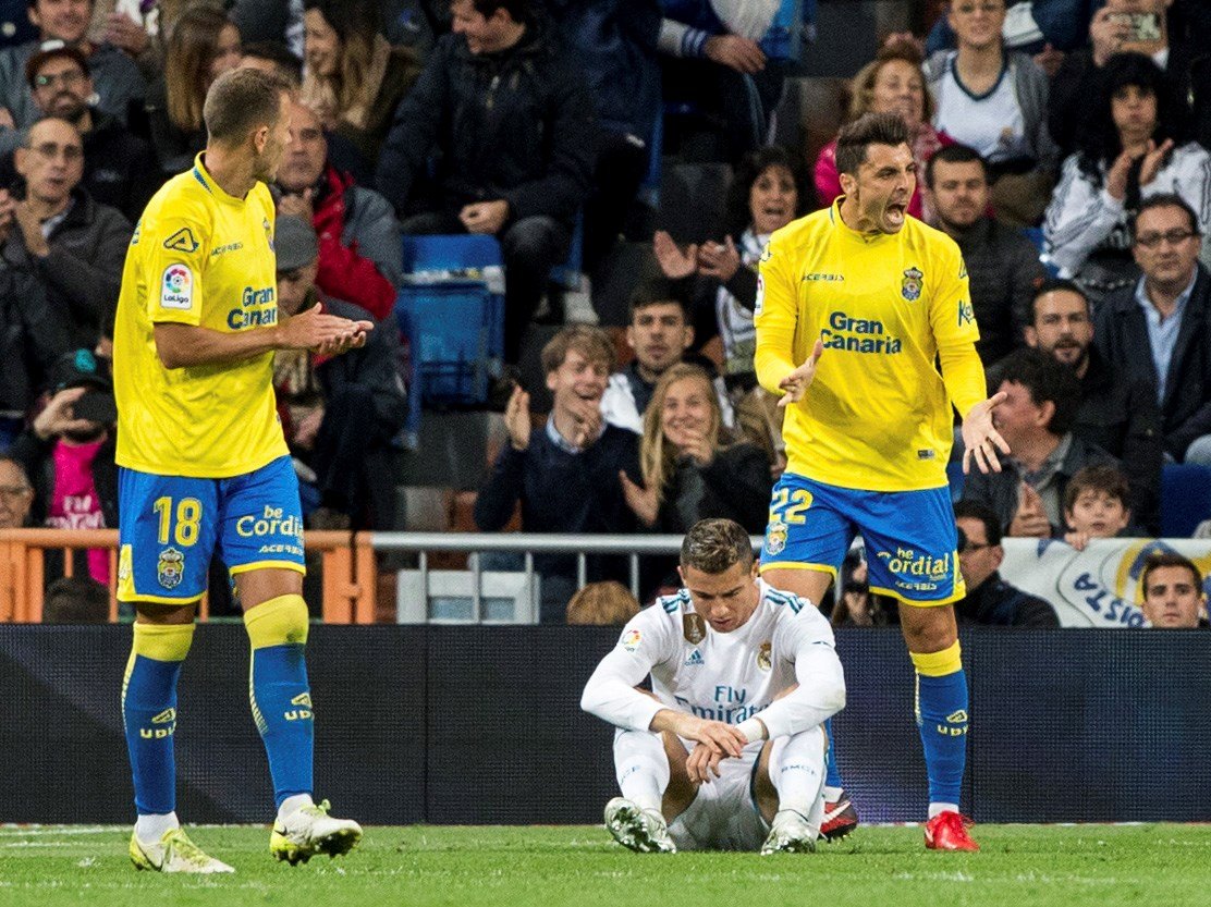 El jugador del Real Madrid Cristiano Ronaldo (c), en el suelo tras una jugada, durante el partido de LaLiga entre Real Madrid y la Unión Deportiva Las Palmas en el estadio Santiago Bernabeu de Madrid. 