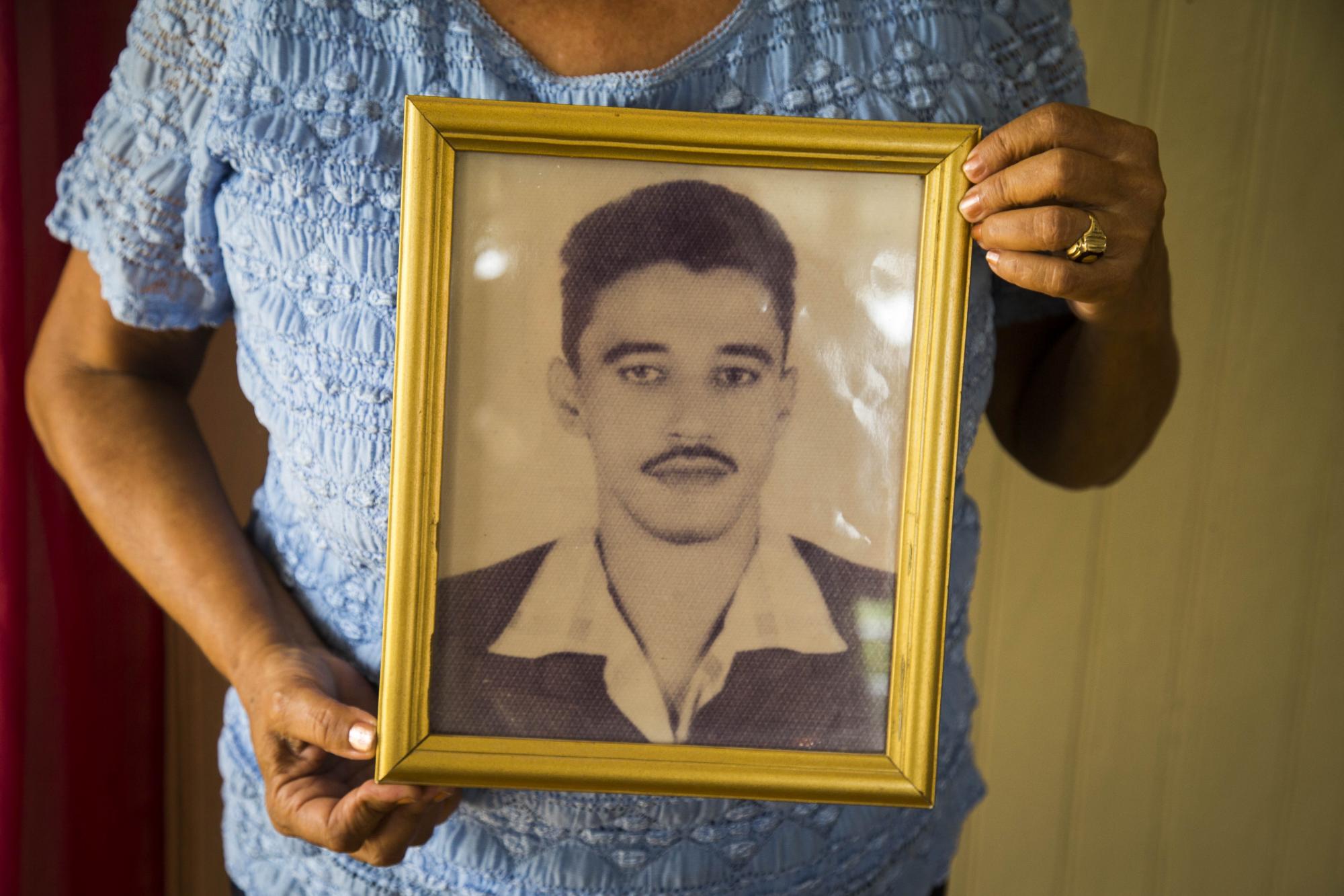 Miledys sostiene la foto de su padre.