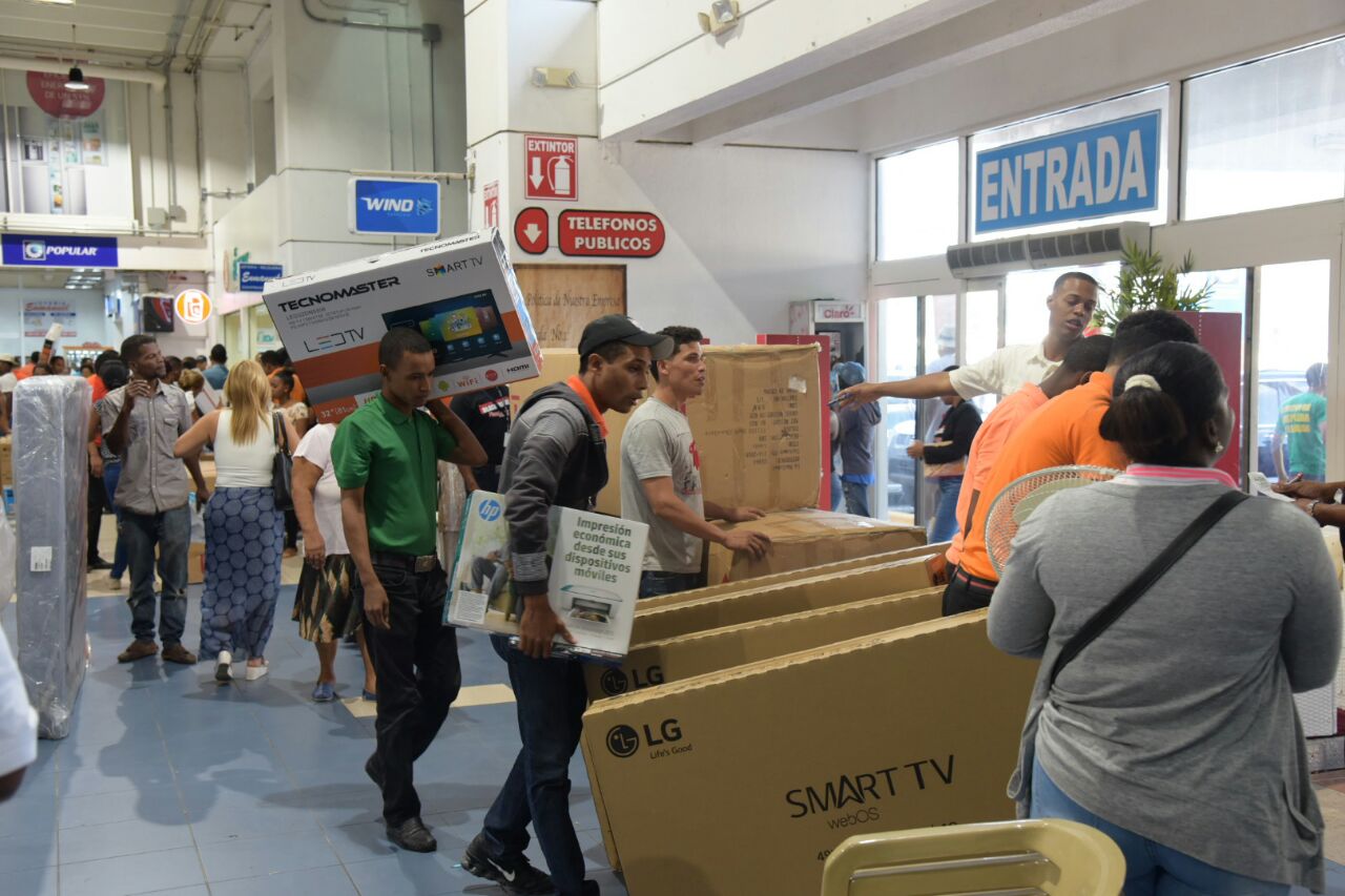 Personas entran y salen de las tiendas en este Black Friday 