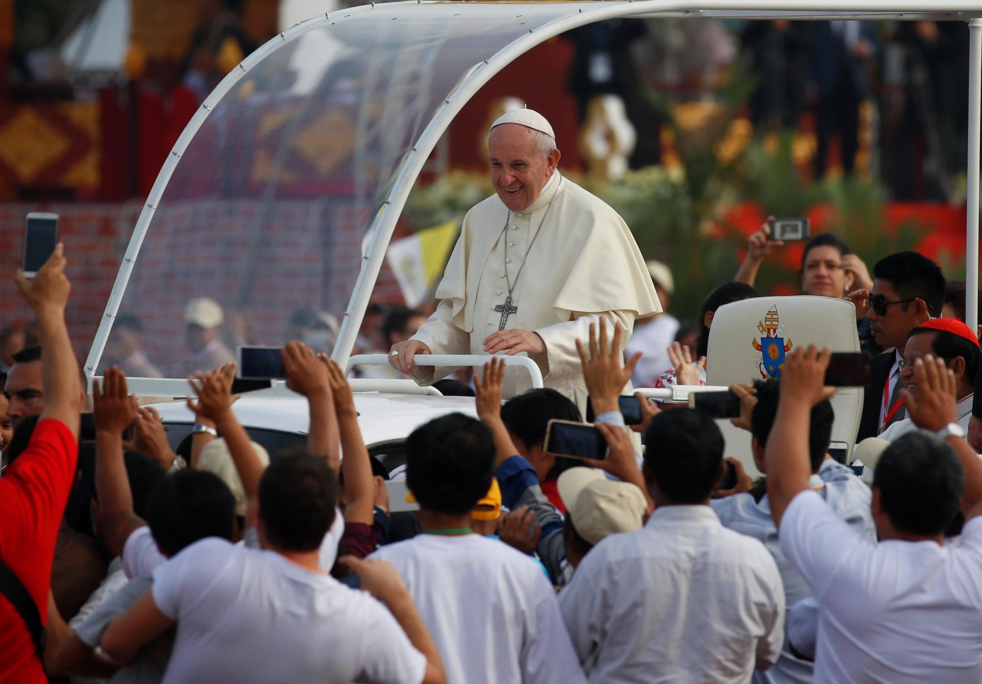 El papa Francisco saluda a los fieles desde el papa móvil por las calles de Rangún (Birmania) hoy, 29 de noviembre de 2017. Francisco celebró hoy una misa campal en Rangún a la que acudieron cerca de 150.000 fieles y en su homilía elogió la ayuda, sin distinción de religión y etnias, de la pequeña comunidad católica presente en Birmania.