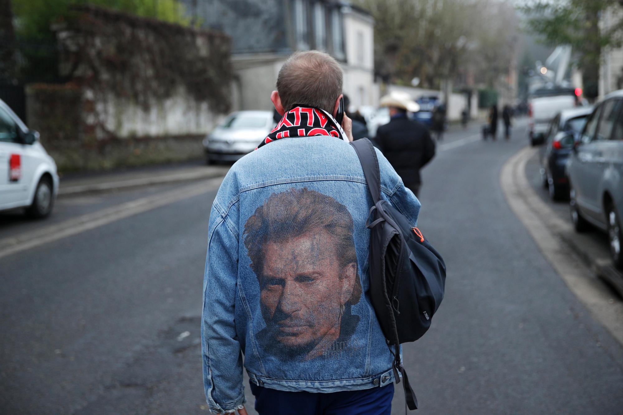  Un fan del artista Johnny Hallyday lleva una chaqueta con su retrato por los alrededores de la vivienda del cantante francés, tras conocerse su fallecimiento, en Marnes-la-Coquette, cerca de París (Francia).