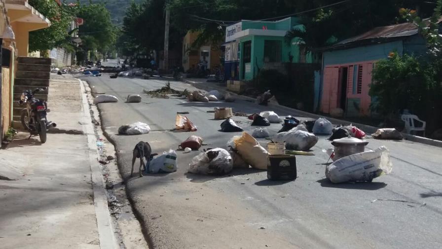 Residentes de barrio Enriquillo  lanzan sacos de basura a la calle 