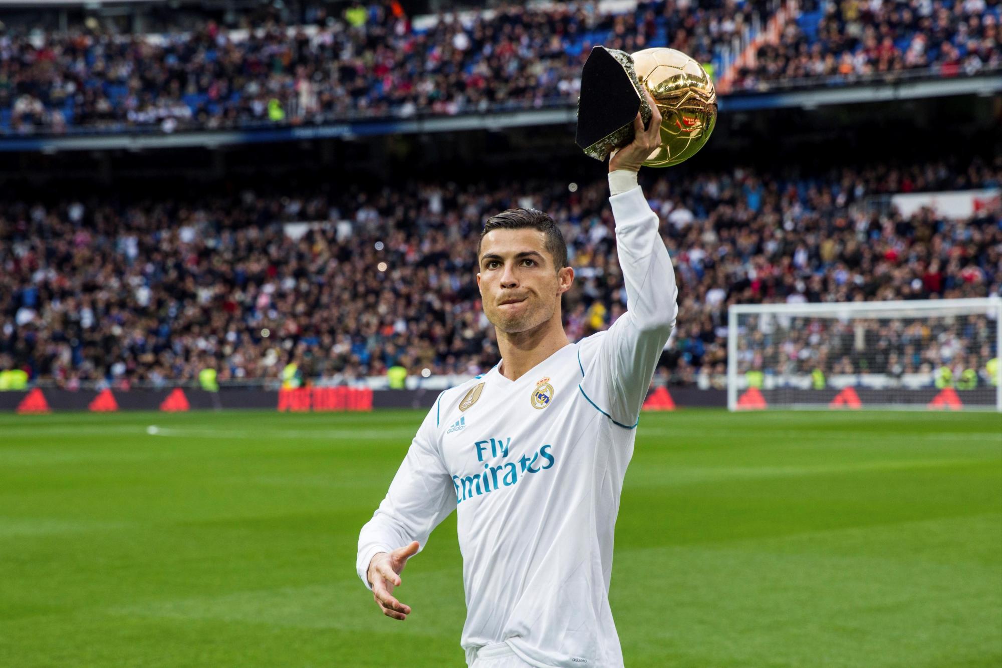 El delantero portugués del Real Madrid Cristiano Ronaldo muestra el trofeo del Balón de Oro antes del partido de liga ante el Sevilla en el estadio Santiago Bernabeu.