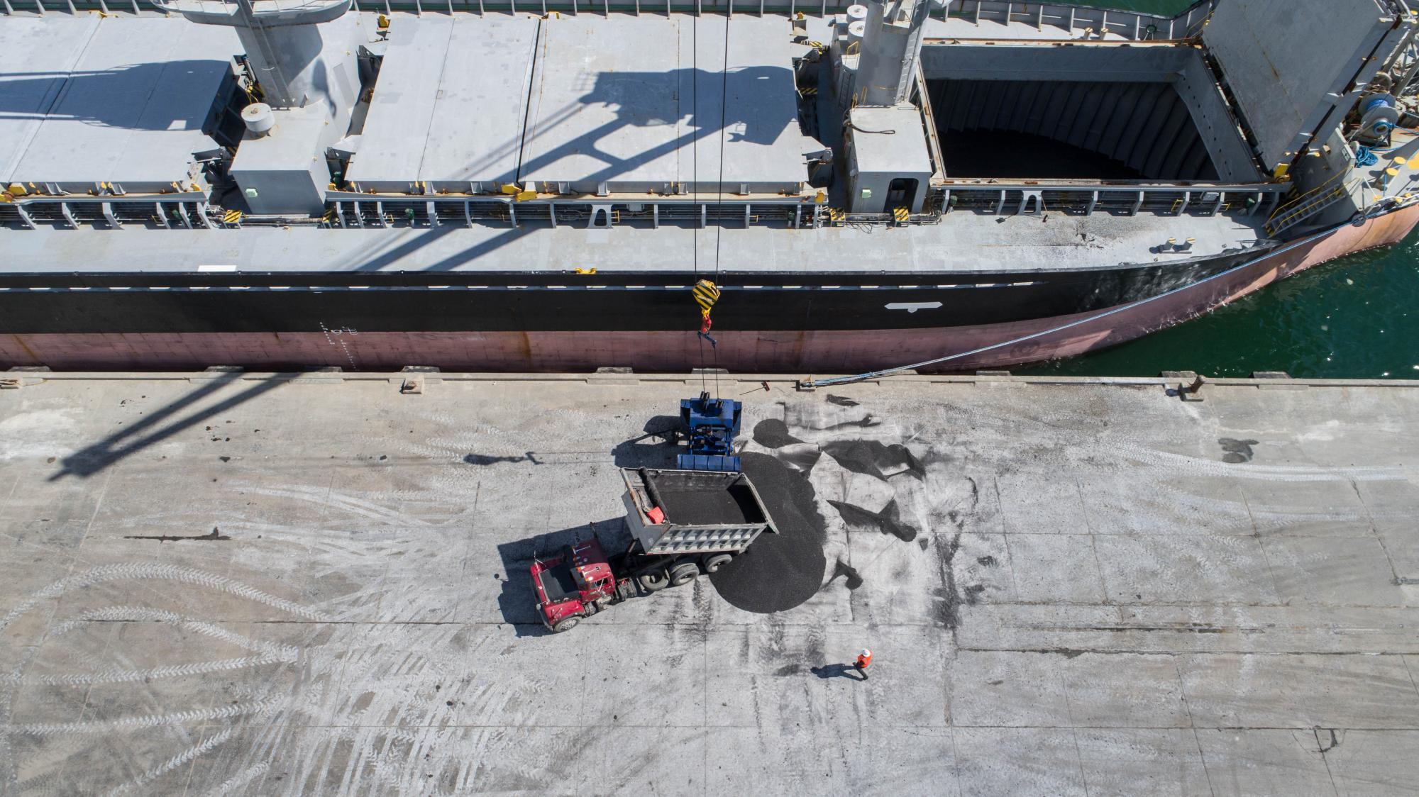 Un camión deposita material para ser embarcado, en el Puerto de Haina.