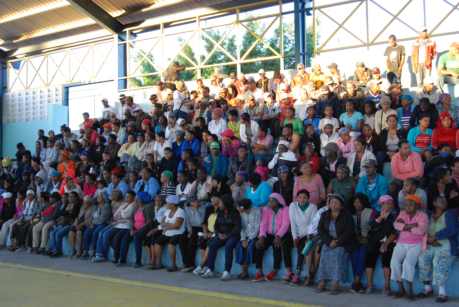 Decenas de personas esperando las cajas en el Polideportivo de Villa Flores, en San Juan de La Maguana.