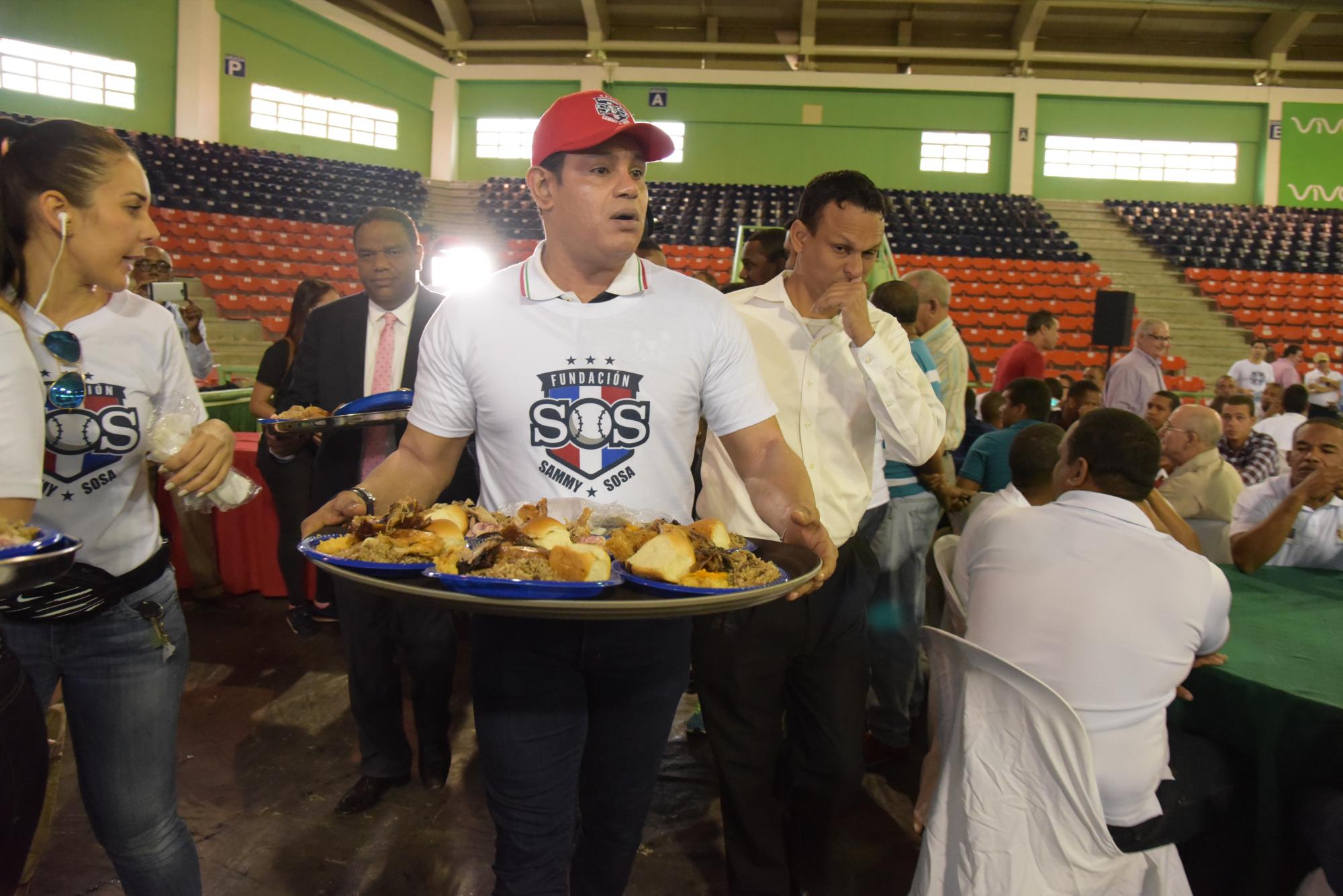 Sammy Sosa en el momento en que se disponía a servir alimentos a cientos de personas necesitadas, con las que compartió un almuerzo y entregó cajas navideñas.