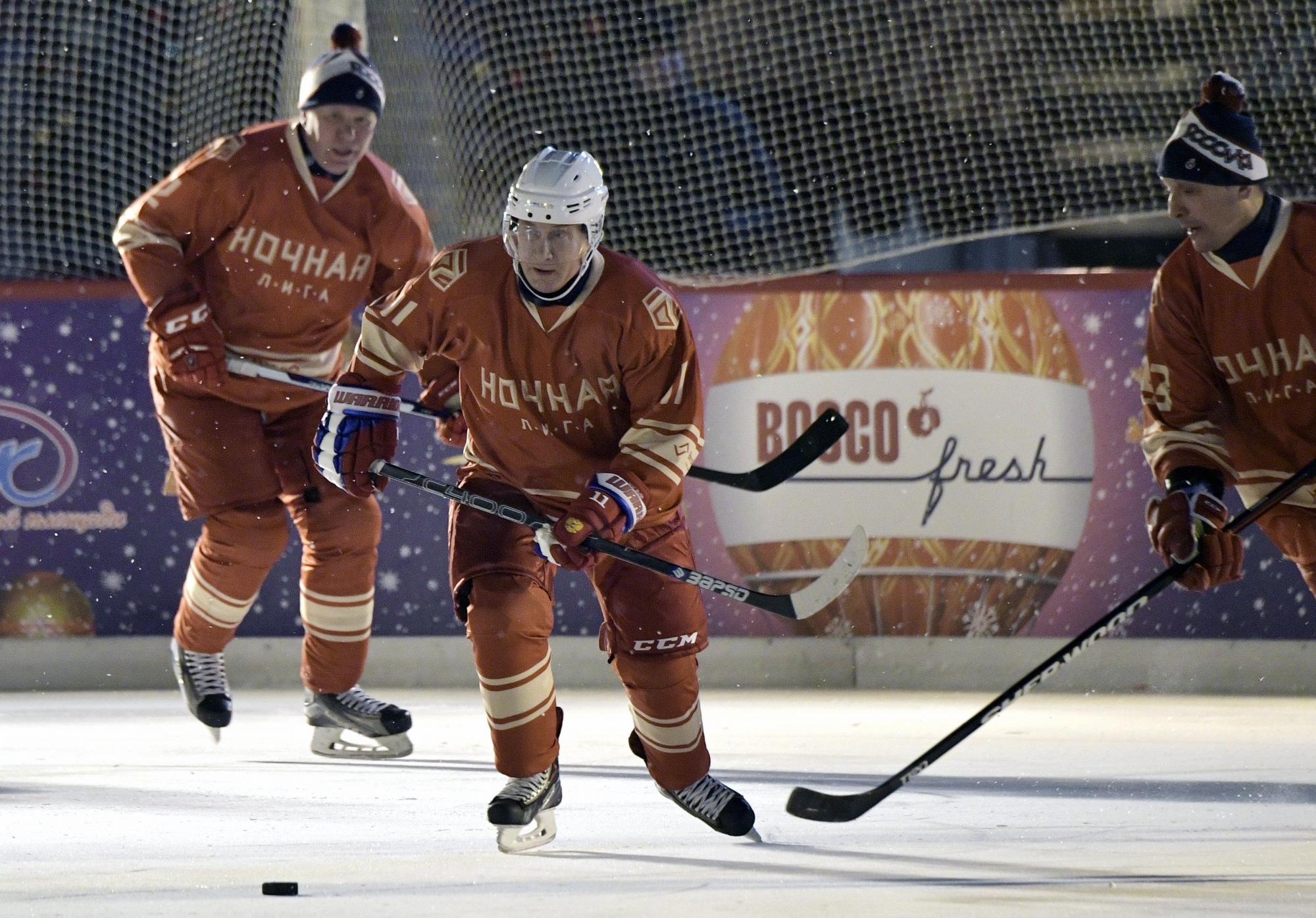 El presidente ruso Vladimir Putin (C) en acción durante el partido de la Liga de Hockey Nocturno en la pista de patinaje GUM en la Plaza Roja en Moscú, Rusia, 22 de diciembre de 2017.