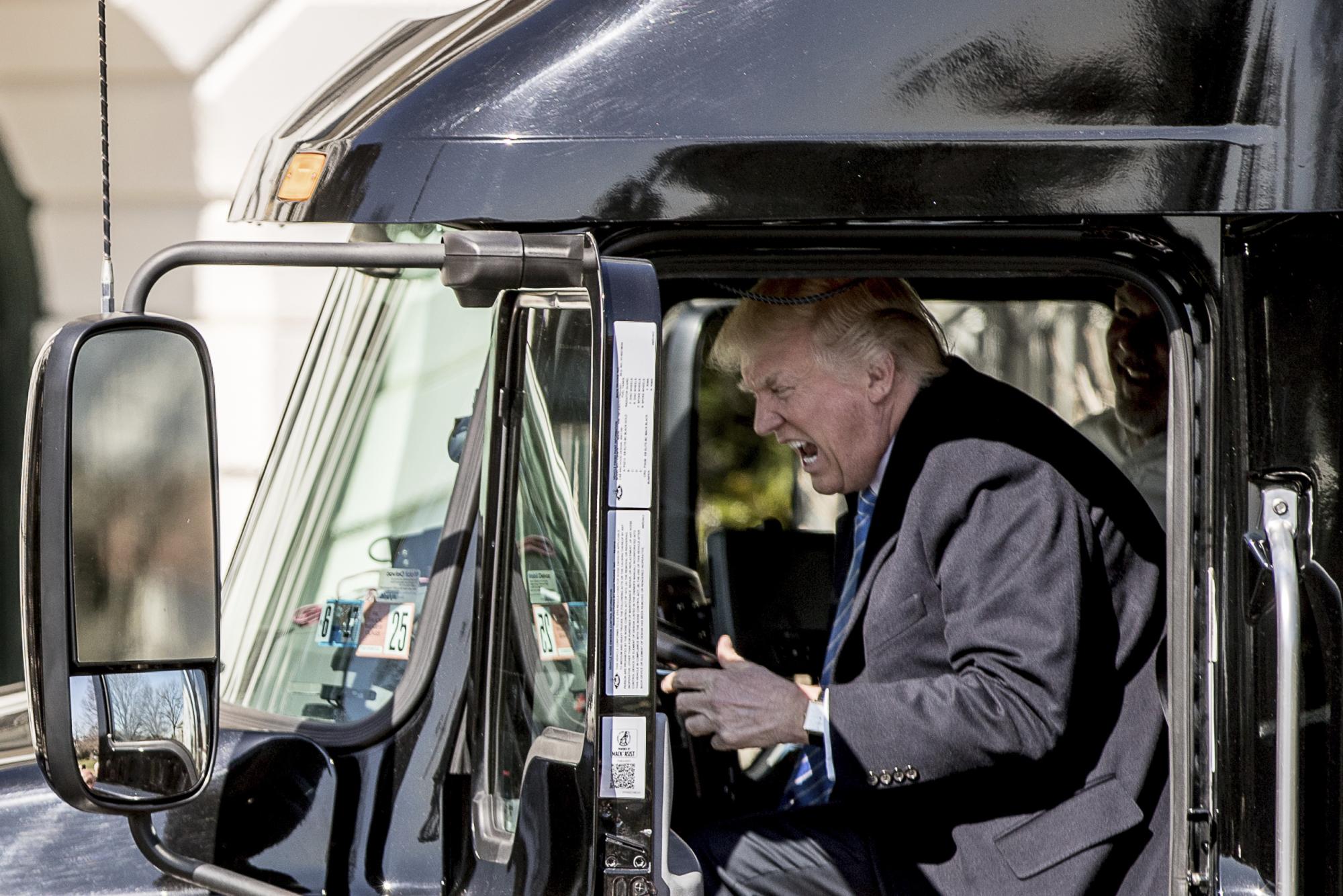 El presidente Donald Trump simula conducir cuando se encuentra en un vehículo de 18 ruedas cuando se reúne con camioneros y directores ejecutivos con respecto a la atención médica en el jardín sur de la Casa Blanca, el jueves 23 de marzo de 2017 en Washington. (AP Photo / Andrew Harnik, Archivo)