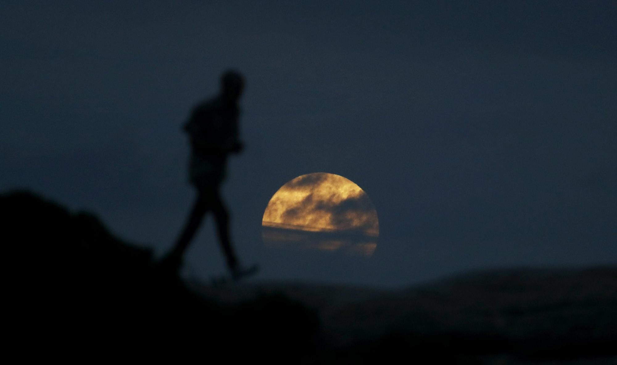 Una mujer observa la luna cerca de la playa Bondi en Sídney (Australia) hoy, 31 de enero de 2018. 