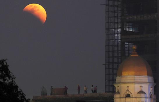 La luna se tiñe de color rojizo en un eclipse total seguido en medio mundo
