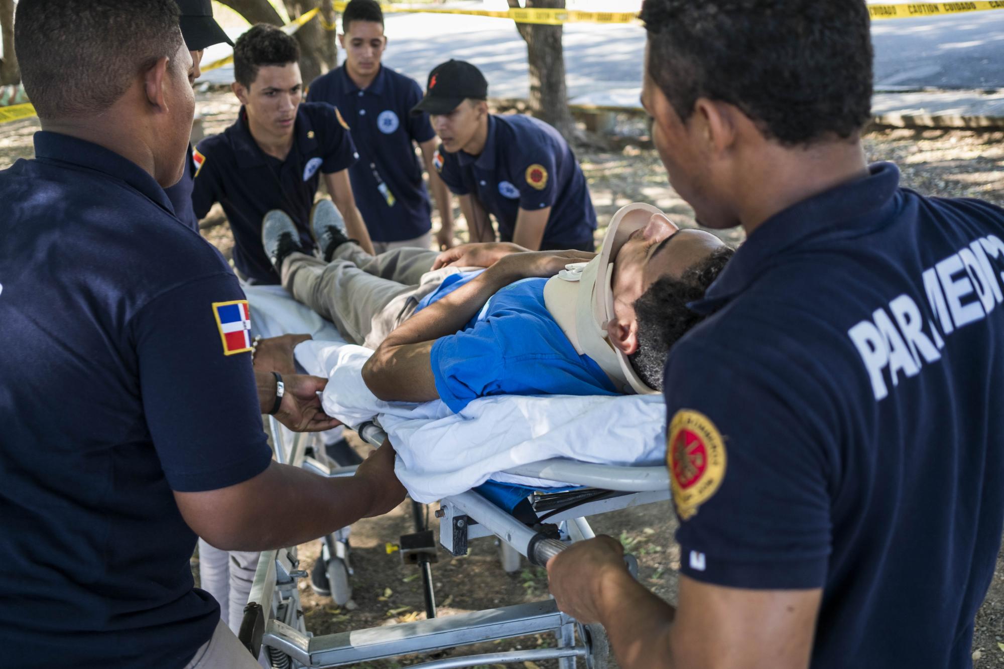 Paramédicos levantan a un accidentado durante un simulacro.