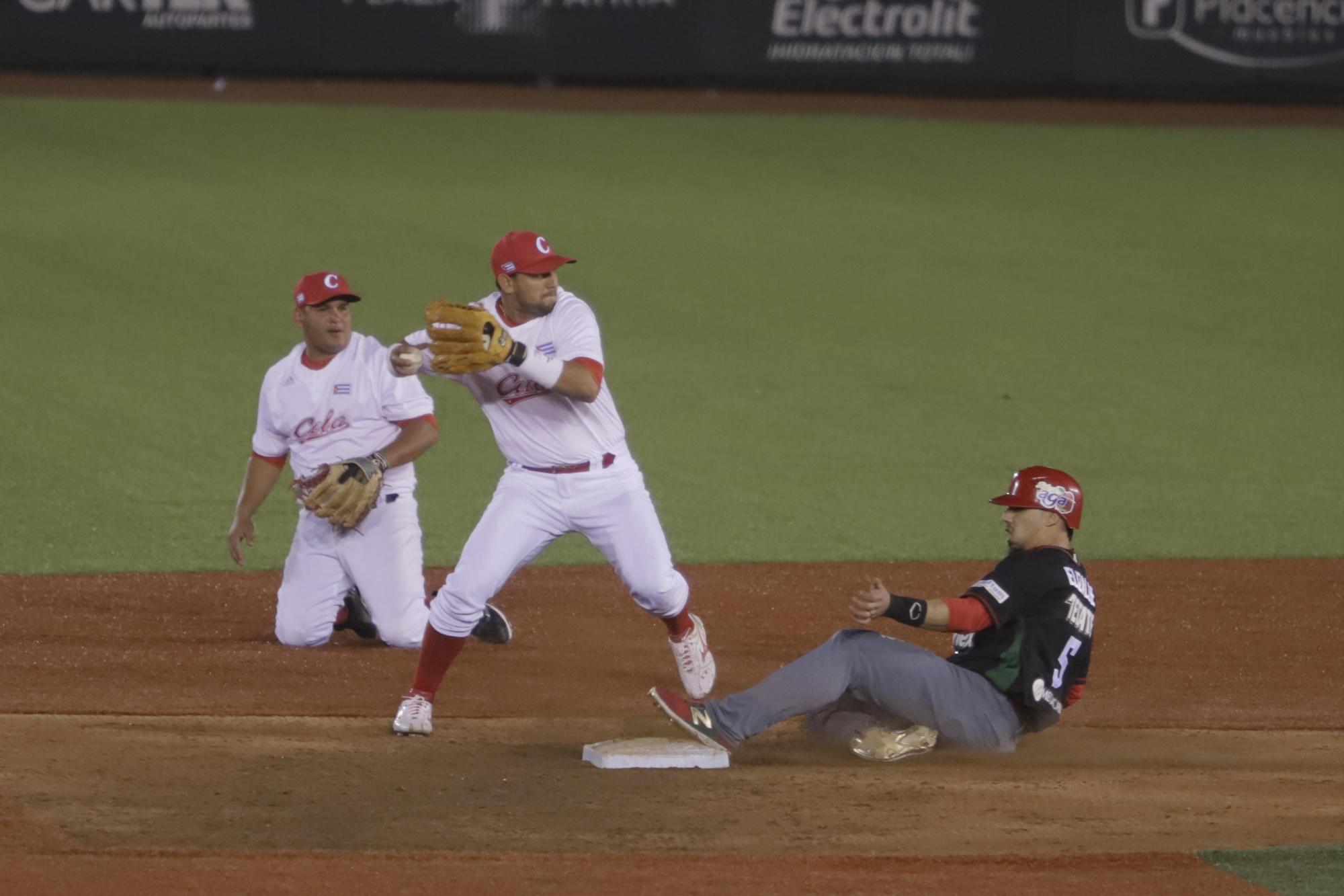 El jugador de los Tomateros de Culiacán Sebastián Elizalde (d) y Jordan Manduley (i) de los Alazanes de Granma de Cuba en acción hoy, sábado 3 de febrero de 2018, durante la segunda jornada de la serie del Caribe 2018 celebrada en el estadio Charros de Jalisco en la Ciudad de Zapopan (México).