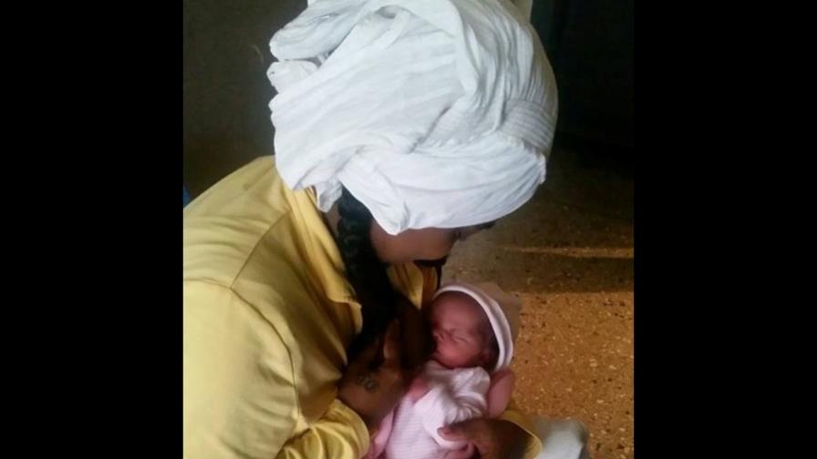 Parturienta amamanta a  su hija en una celda de un cuartel policial de La Romana
