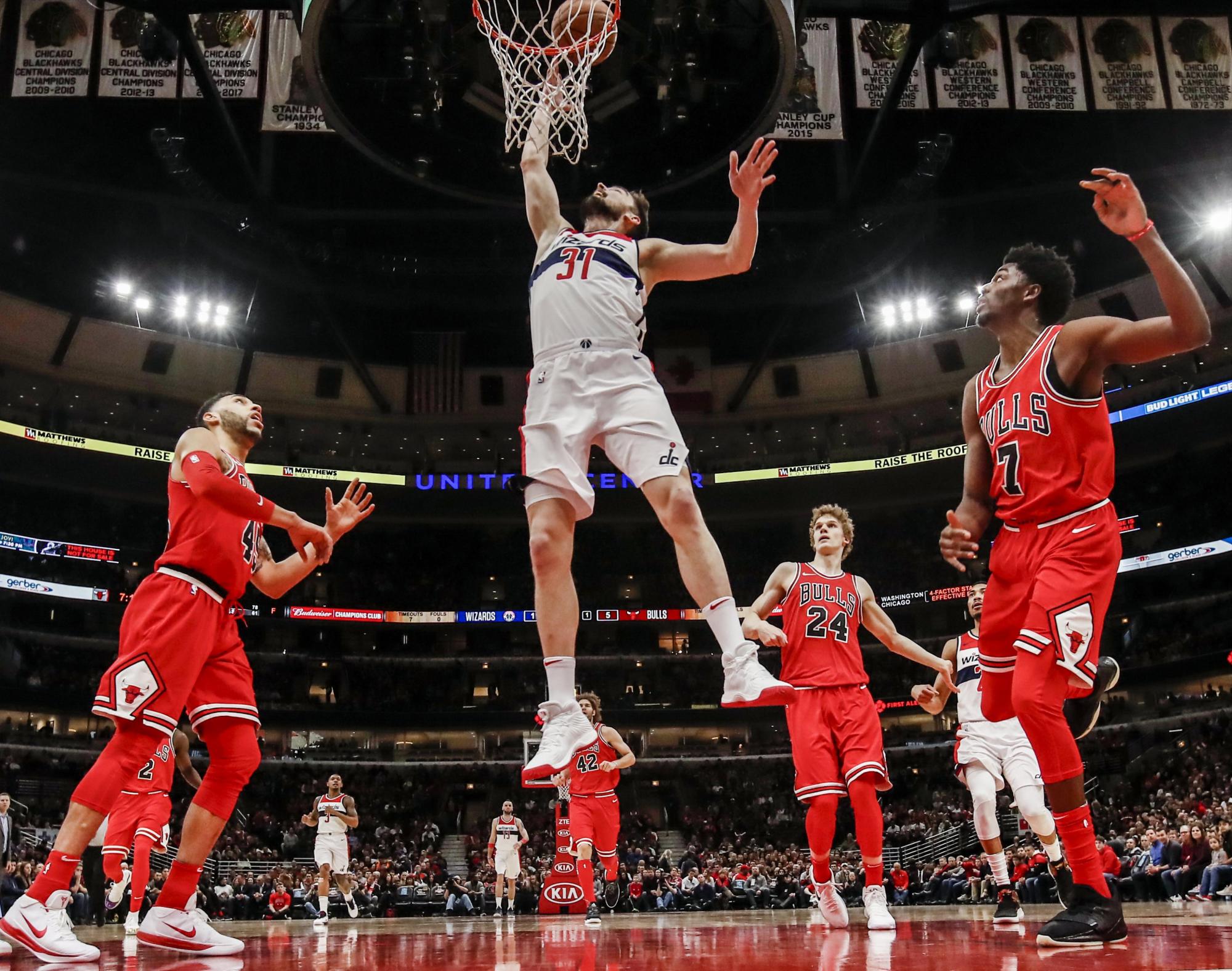  El alero de Washington Wizards Tomas Satoransky de la República Checa (2-L) tira delante del guarda de Chicago Bulls Denzel Valentine (L), el alero de Chicago Bulls Lauri Markkanen de Finlandia (2- R) y los Chicago Bulls resguardan a Justin Holiday (R) en la primera mitad de su juego de la NBA en el United Center en Chicago, Illinois.