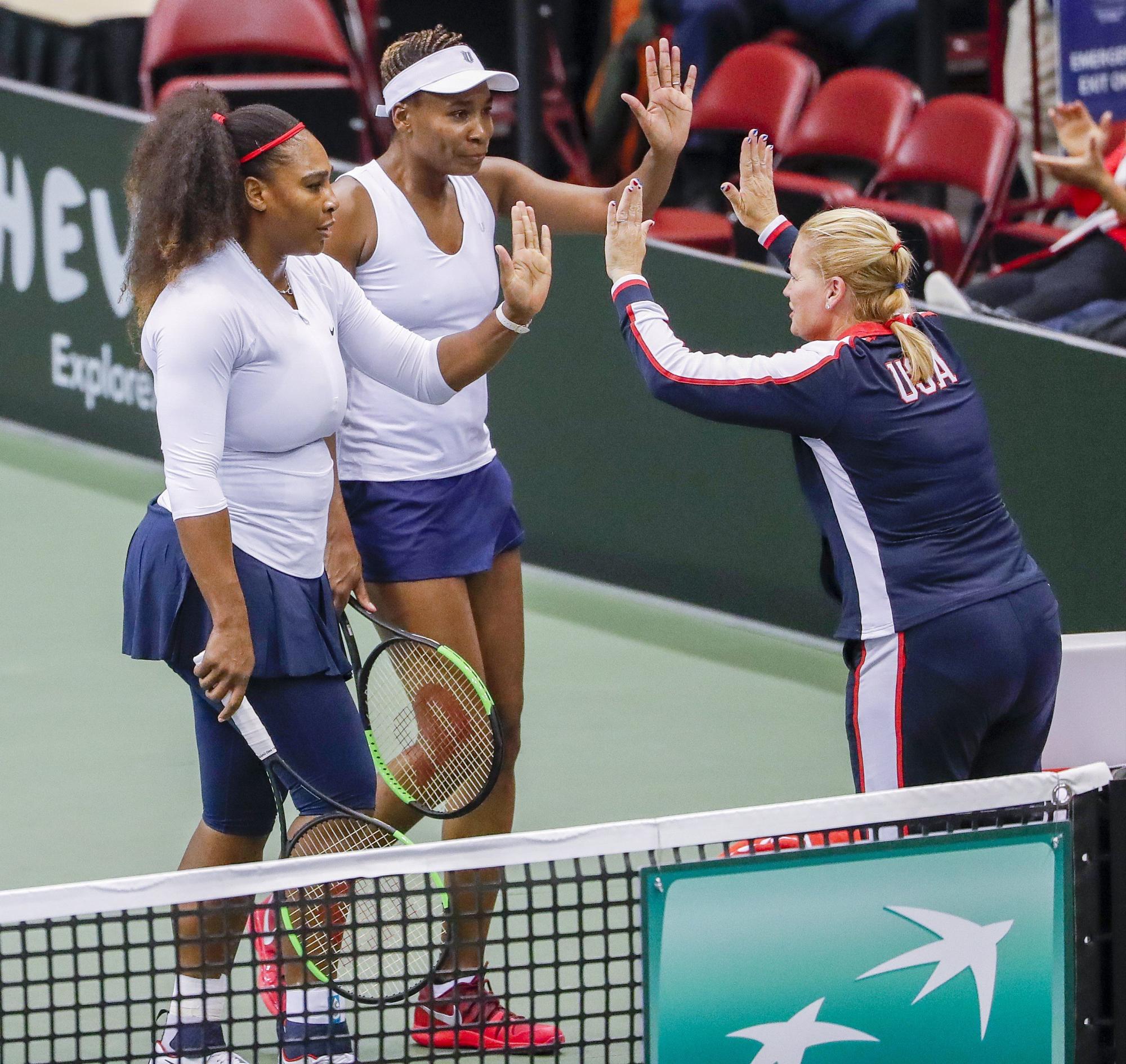 Serena Williams (L) de EE. UU. Con su hermana Venus Williams (C) de los EE. UU. Son recibidos por la capitana Kathy Rinaldi durante un partido de dobles contra Lesley Kerkhove y Demi Schuurs de la Países Bajos durante un partido de tenis femenino de la primera ronda de Fed Cup World Group entre los Estados Unidos y los Países Bajos en el US Cellular Center en Asheville.
