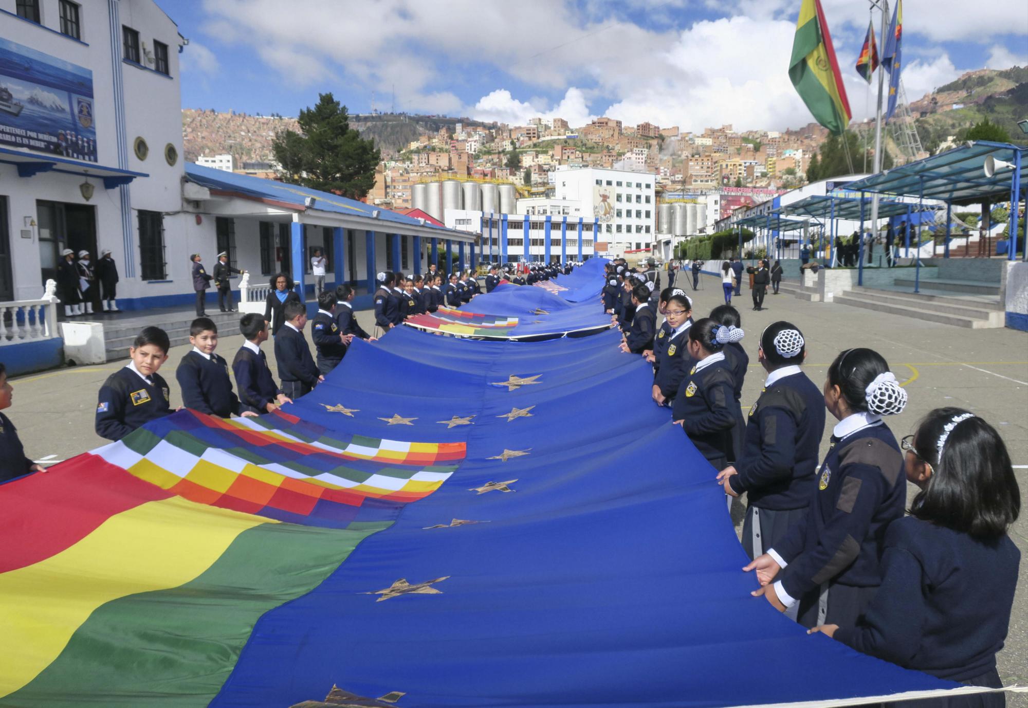 Estudiantes de la Unidad Educativa Héroes del Pacífico en La Paz muestran el primer tramo de una bandera de setenta kilómetros con la que Bolivia espera el próximo 10 de marzo batir un récord mundial, hoy jueves, 15 de febrero de 2018, en La Paz (Bolivia). La Armada de Bolivia, con apoyo de estudiantes del país, comenzó a coser la bandera con la que aspira al récord, en apoyo a su demanda ante Chile sobre una salida al mar.