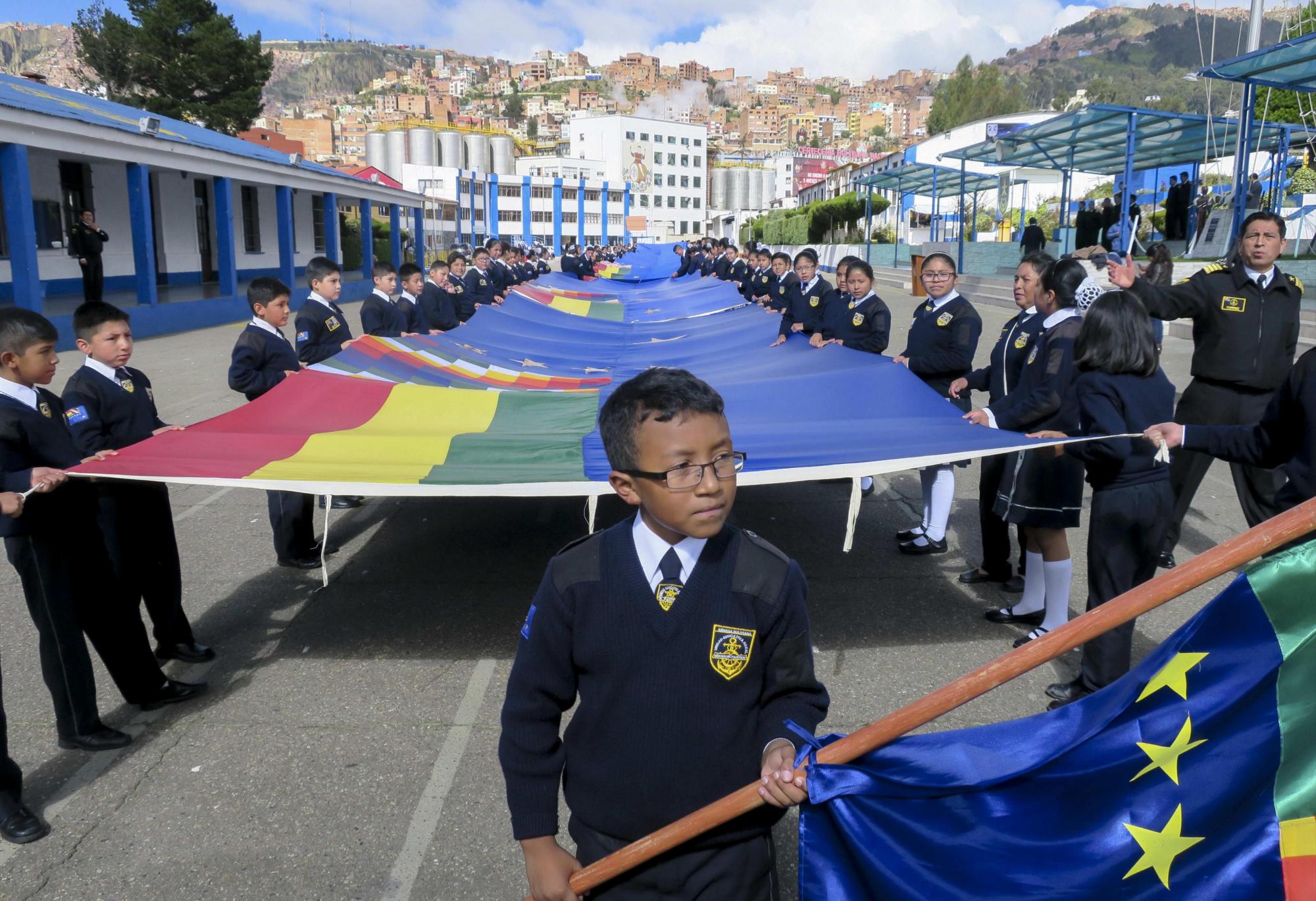 Estudiantes de la Unidad Educativa Héroes del Pacífico en La Paz muestran el primer tramo de una bandera de setenta kilómetros con la que Bolivia espera el próximo 10 de marzo batir un récord mundial, hoy jueves, 15 de febrero de 2018, en La Paz (Bolivia). La Armada de Bolivia, con apoyo de estudiantes del país, comenzó a coser la bandera con la que aspira al récord, en apoyo a su demanda ante Chile sobre una salida al mar.
