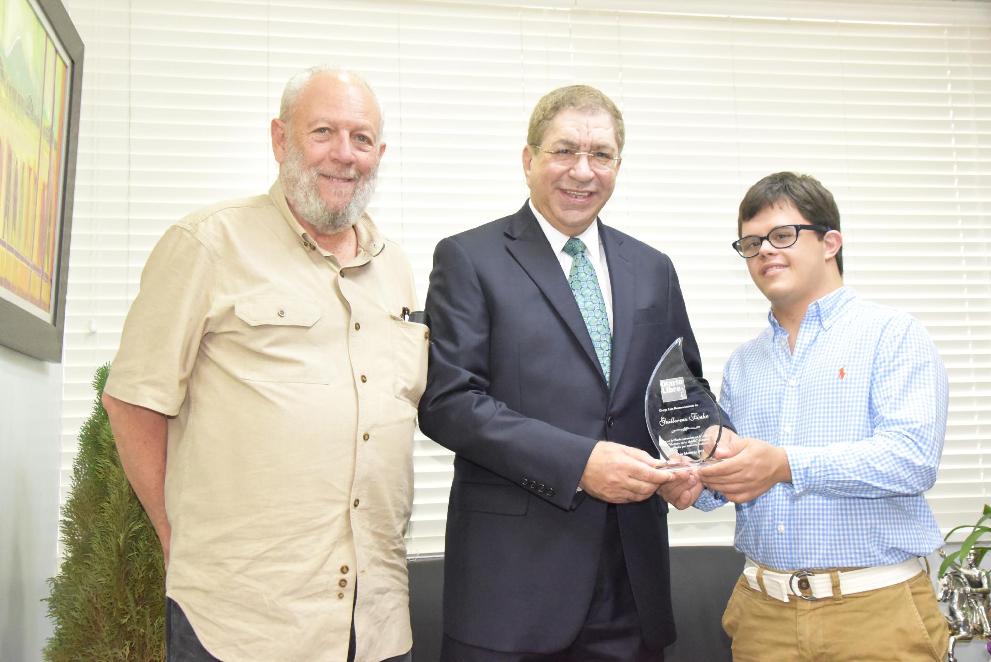 A la derecha Guillermo Finke recibe el premio de los lectores, de mano de Adriano Miguel Tejada, flanquado por Freddy Ginebra.