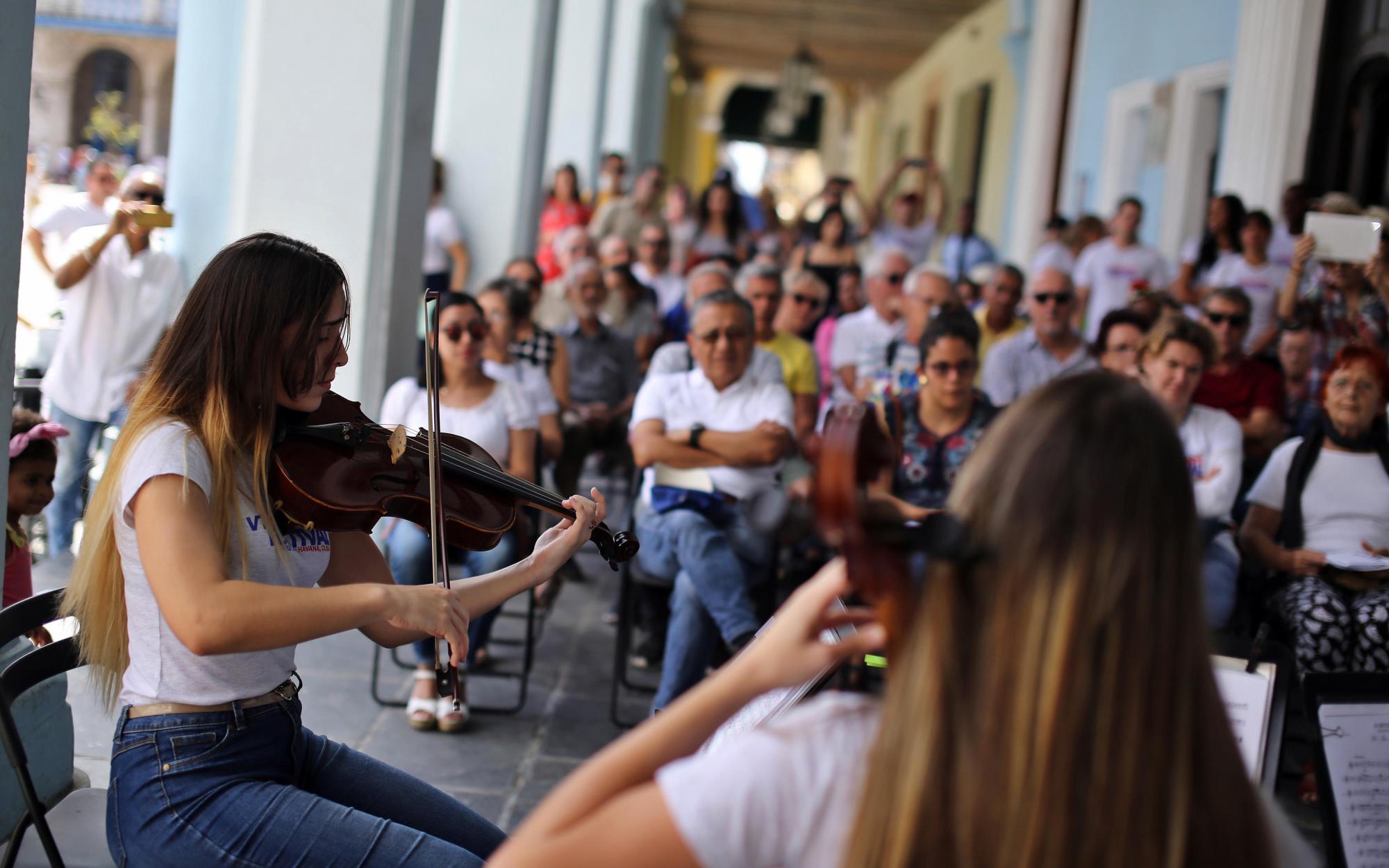 jóvenes músicos, integrantes del cuarteto de cuerda Alma, interpretan música de Mozart hoy, sábado 24 de febrero, en un portal del centro histórico de La Habana (cuba). En medio del bullicio de La Habana Vieja, la música de Wolfgang Amadeus Mozart (1756-1791) coincide hoy, solo por un día, con la rumba y el son que ambientan el Centro Histórico de la capital cubana, donde por primera vez se escucharán en vivo los 24 cuartetos de cuerda del genio austríaco.