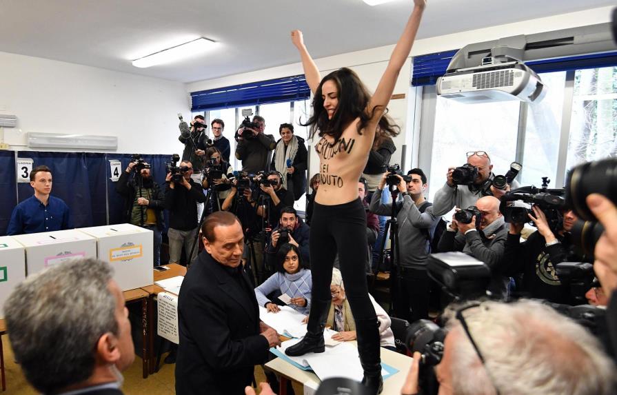 Una activista de Femen sin camiseta interrumpe a Berlusconi en su votación