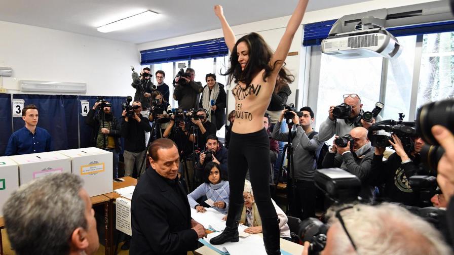 Una activista de Femen sin camiseta interrumpe a Berlusconi en su votación