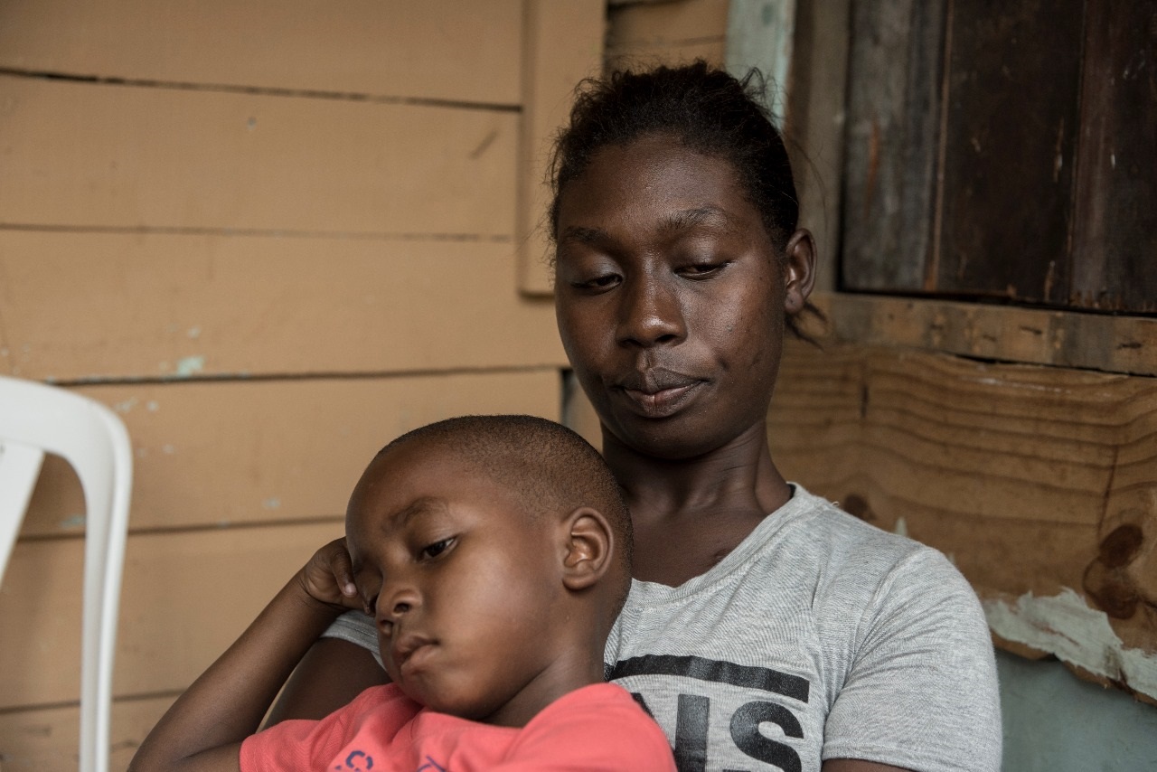 En esta imagen, Sheyla Figueroa, madre del infante fallecido por difteria, se ve junto a su otro hijo de seis años, en el barrio El Chucho de Los Alcarrizos, Santo Domingo.