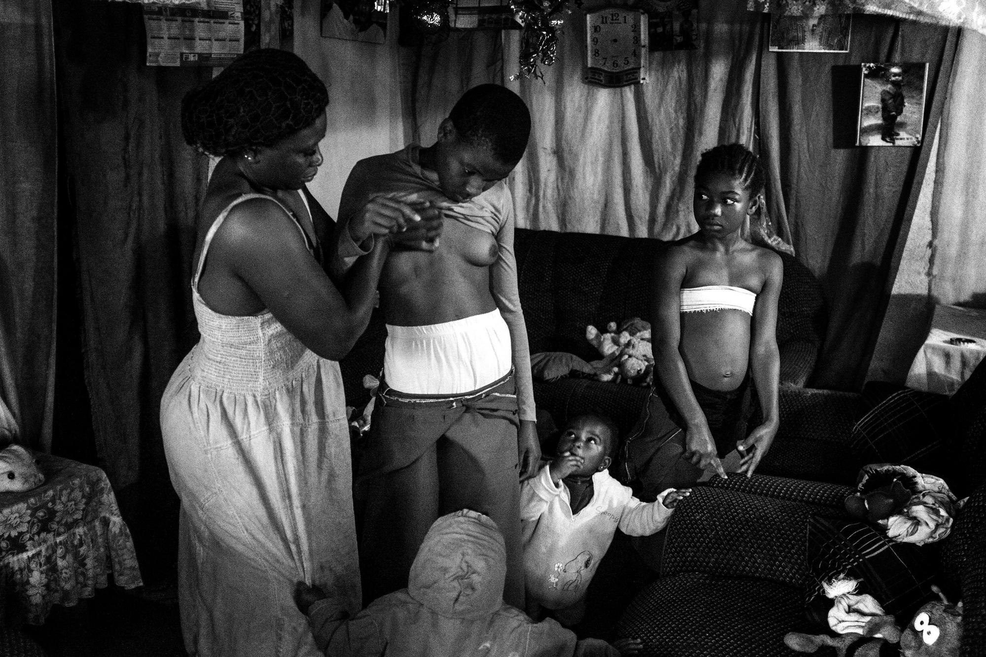 Imagen captada por la fotógrafa Heba Khamis, ganadora del 1er premio de la categoría Contemporary Issues. La foto muestra a Veronica, de 28 años, mientras masaje el pecho de su hija de 10 años Michelle, en compañía de sus otras hijas en Bafoussam, Camerún, el 7 de noviembre de 2016.
