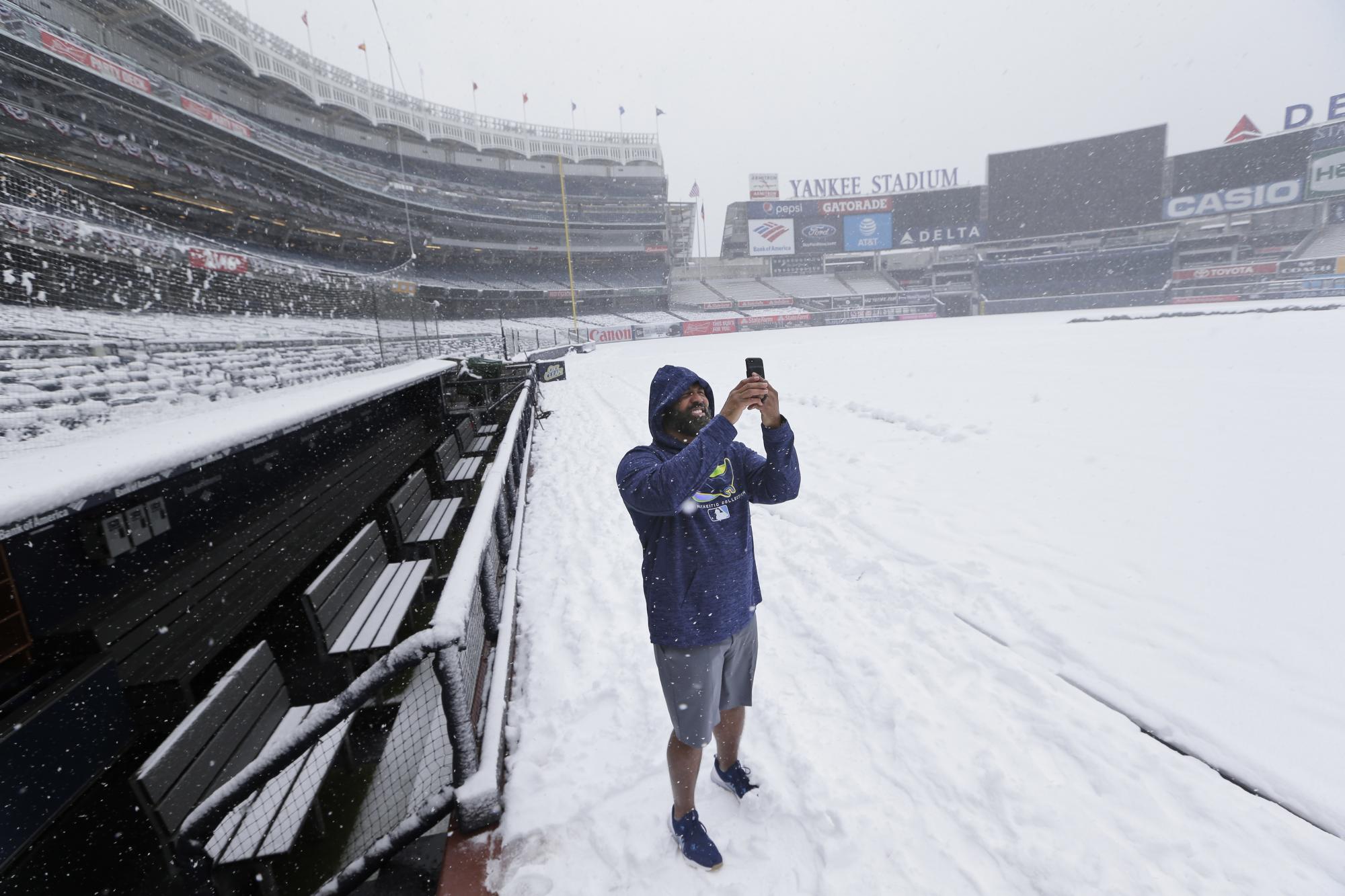 Rayford Allen, un empleado de los Tampa Bay Rays, toma algunas fotos con su móvil en un Yankee Stadium cubierto de nieve, el pasado 2 de abril. 