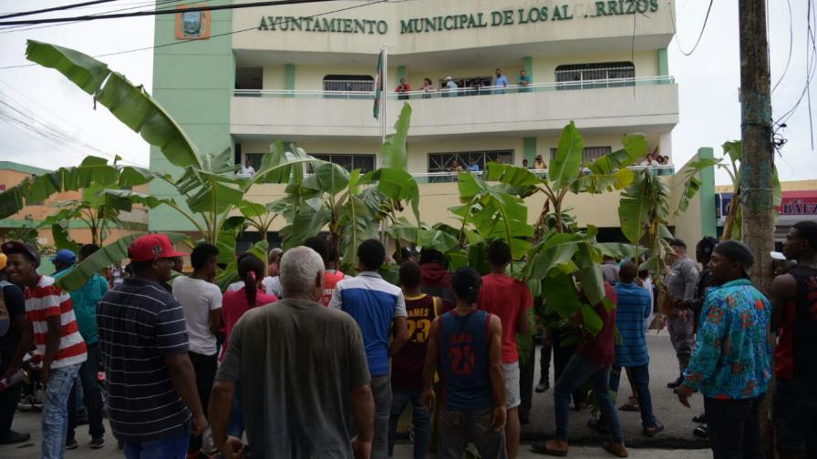 Comunitarios siembran matas de plátanos en Los Alcarrizos en demanda de arreglo de calles