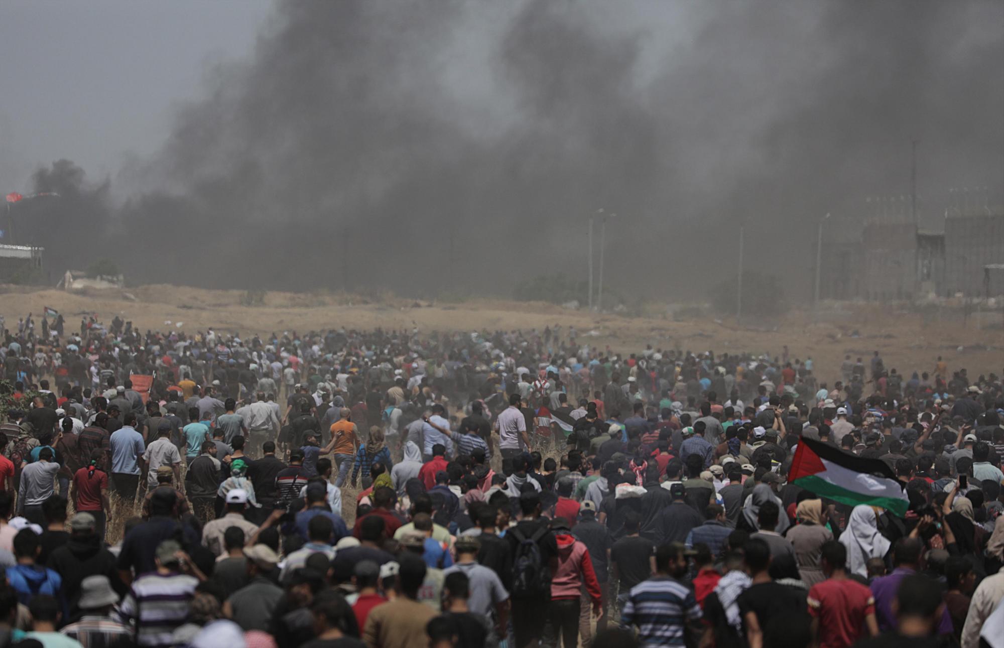 Cientos de palestinos congregados durante los enfrentamientos surgidos tras las protestas convocadas cerca de la frontera con Israel en el este de la franja de Gaza, el 14 de mayo de 2018. 