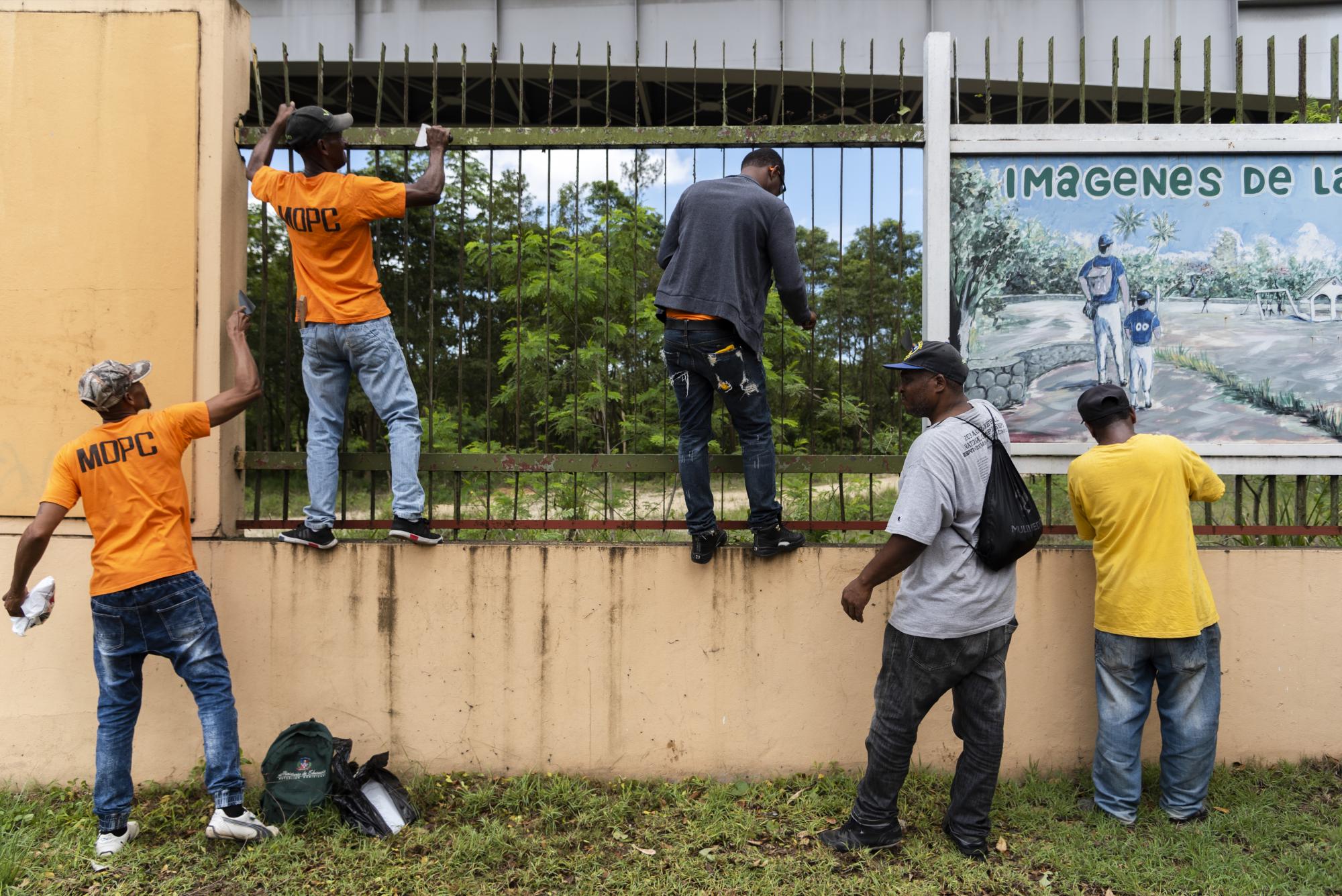 Empleados pintan parte de la verja en la avenida Hermanas Mirabal 
