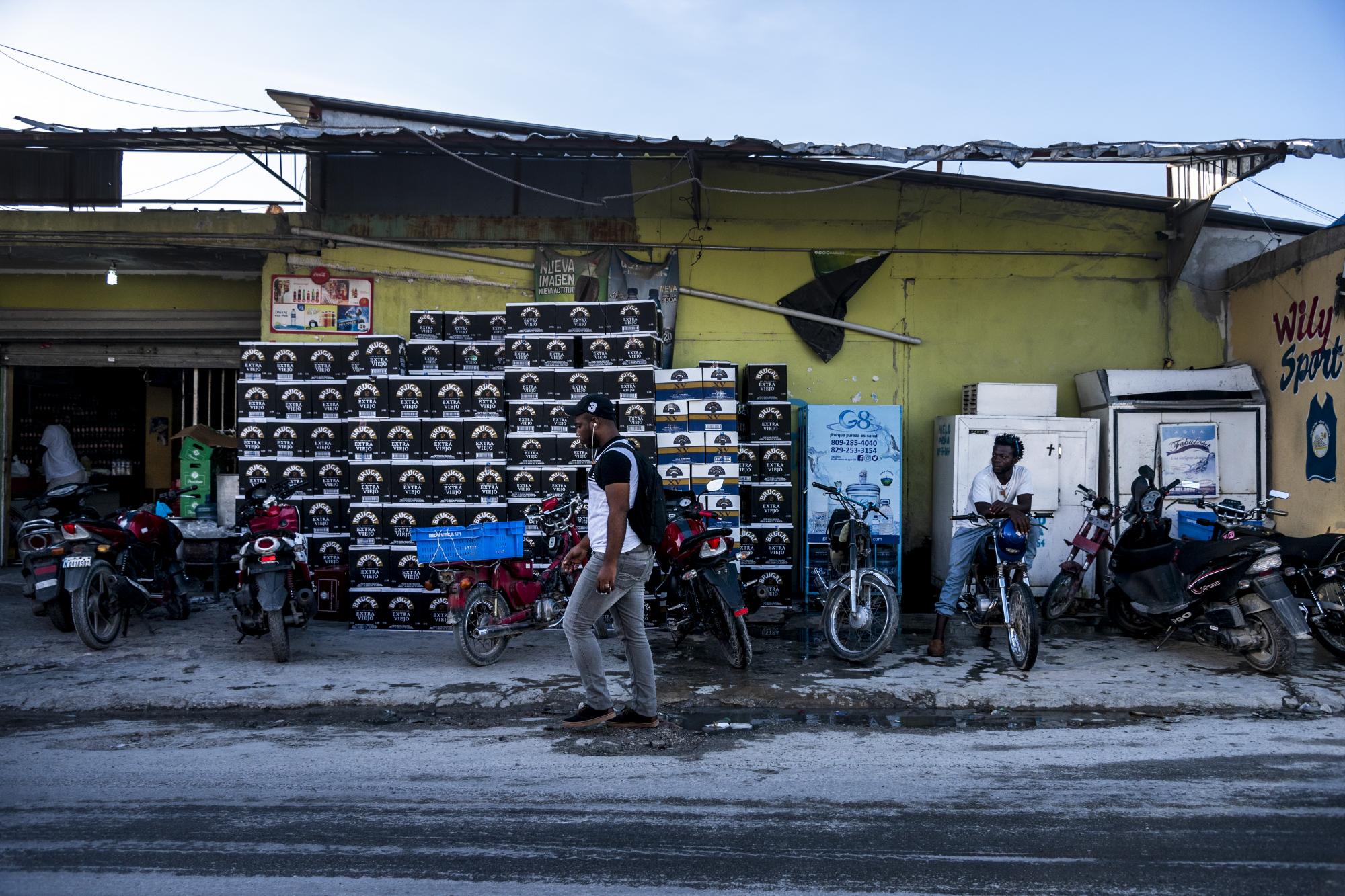 Los motoconchos comparten acera con mercancías en una de la calles de Friusa.