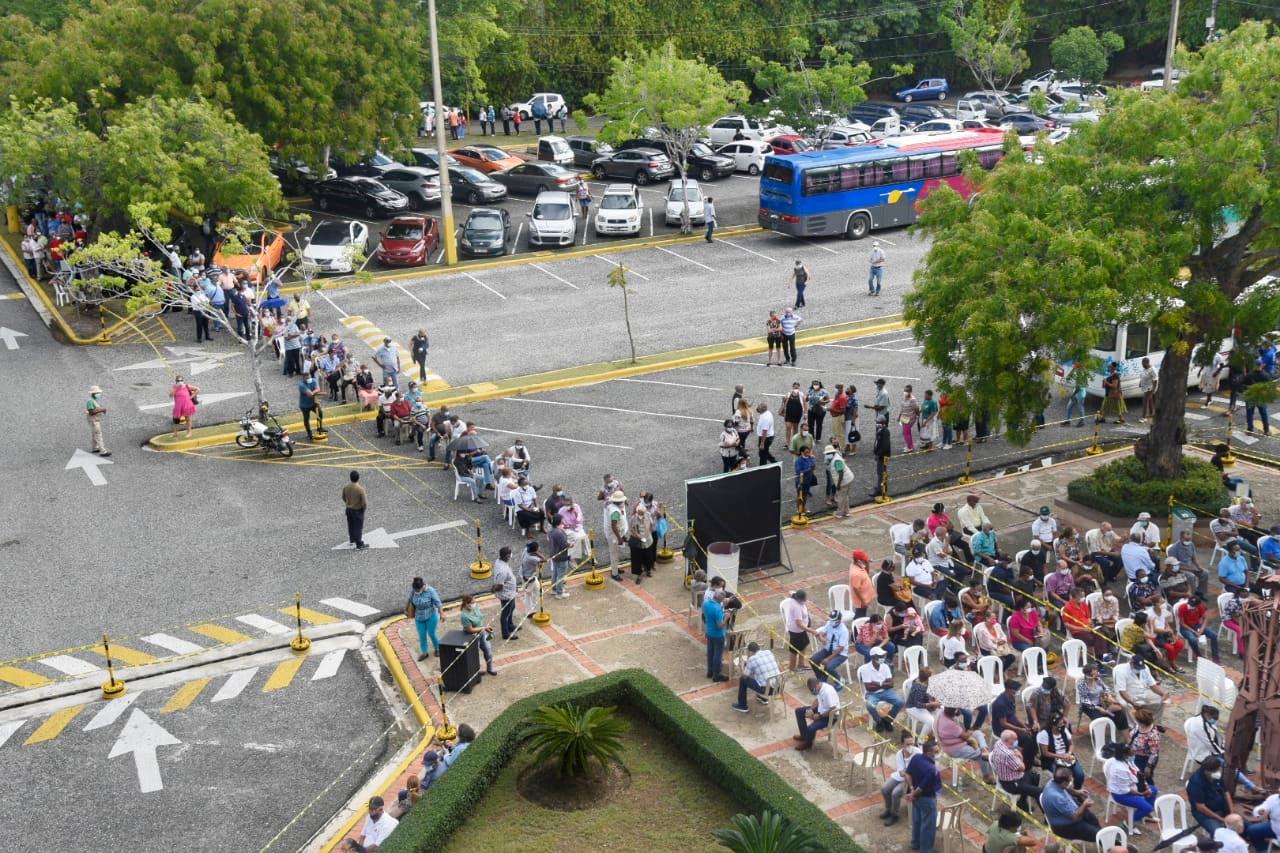Tantas son las personas que llegan hoy en busca de su segunda dosis en la Unphu que todas las áreas de esperas están llenas, por lo cual se ha creado una fila que casi dobla a uno de los parqueos. 