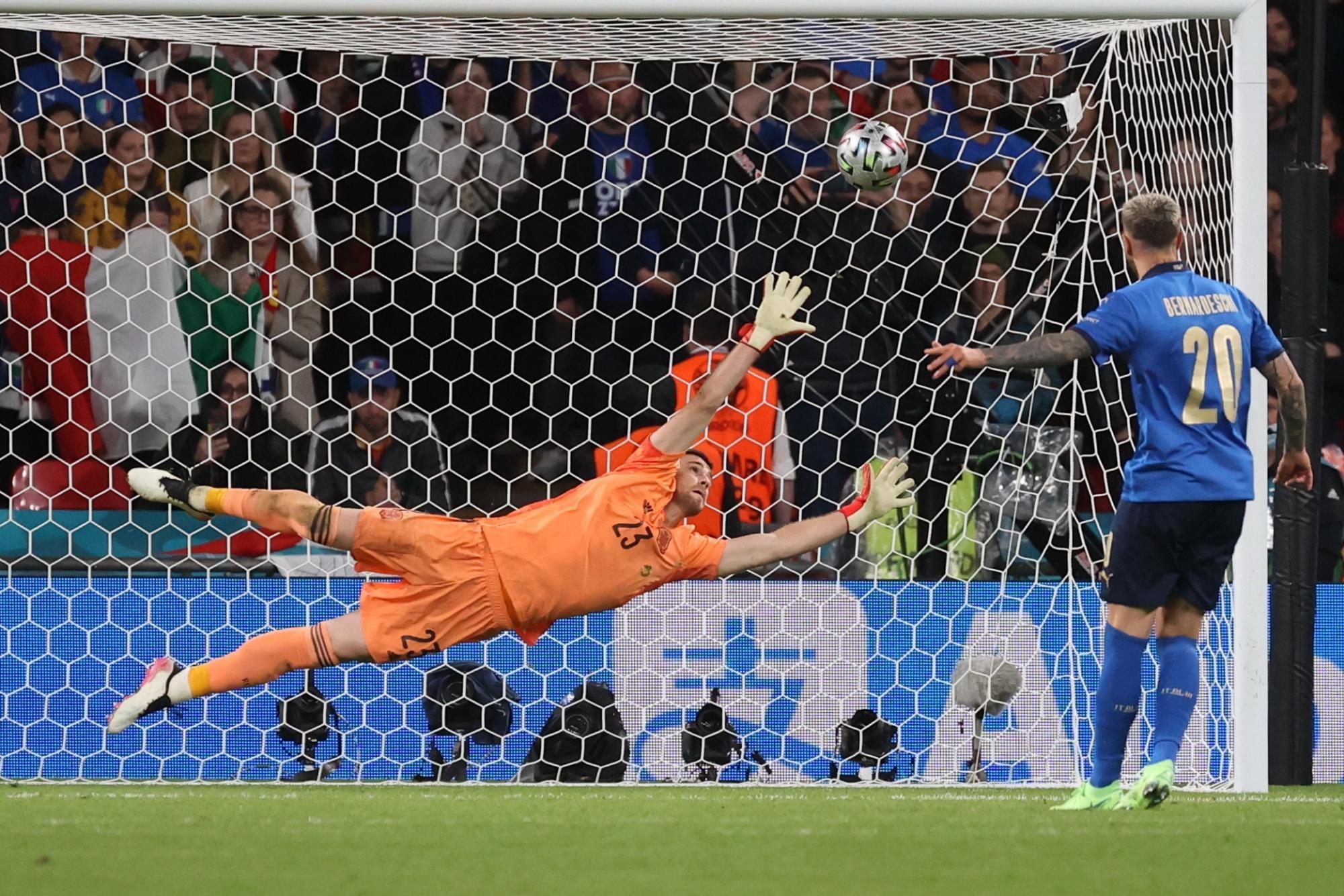 El jugador de la selección italiana de fútbol Bernardeschi (d) marca ante Unai Simón, portero de España, durante el partido de semifinales de la Eurocopa 2020 entre España e Italia disputado este martes en el estadio de Wembley, en Londres. (EFE/Kiko Huesca)