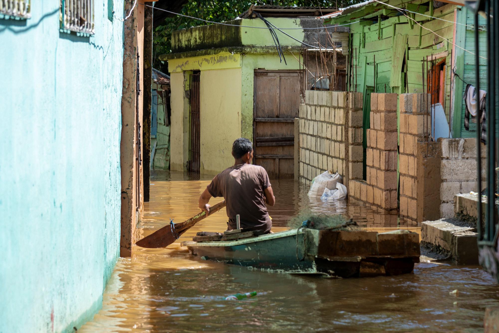 señor en bote transita en medio de las inundaciones