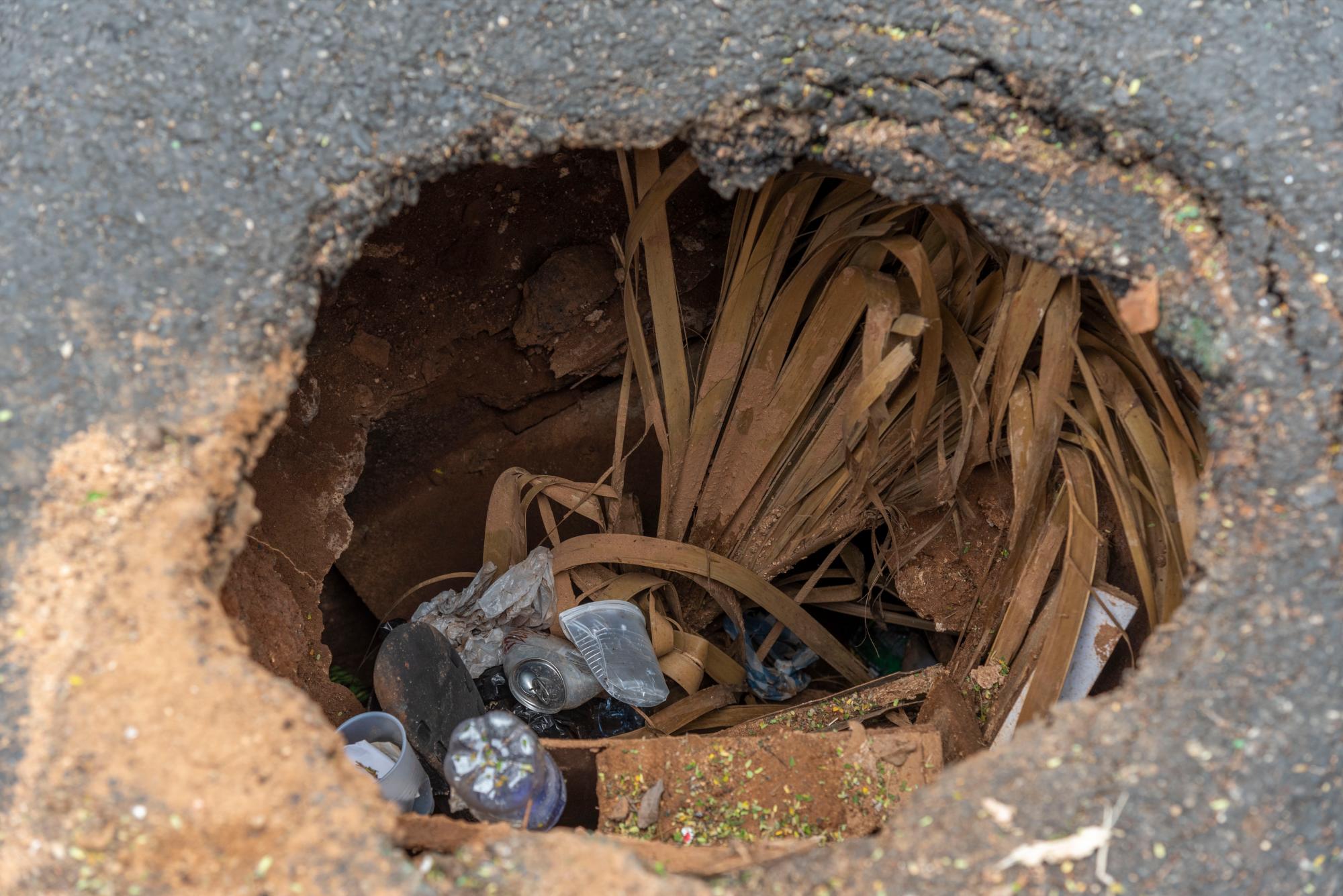 Algunas personas lanzan basura a los hoyos.